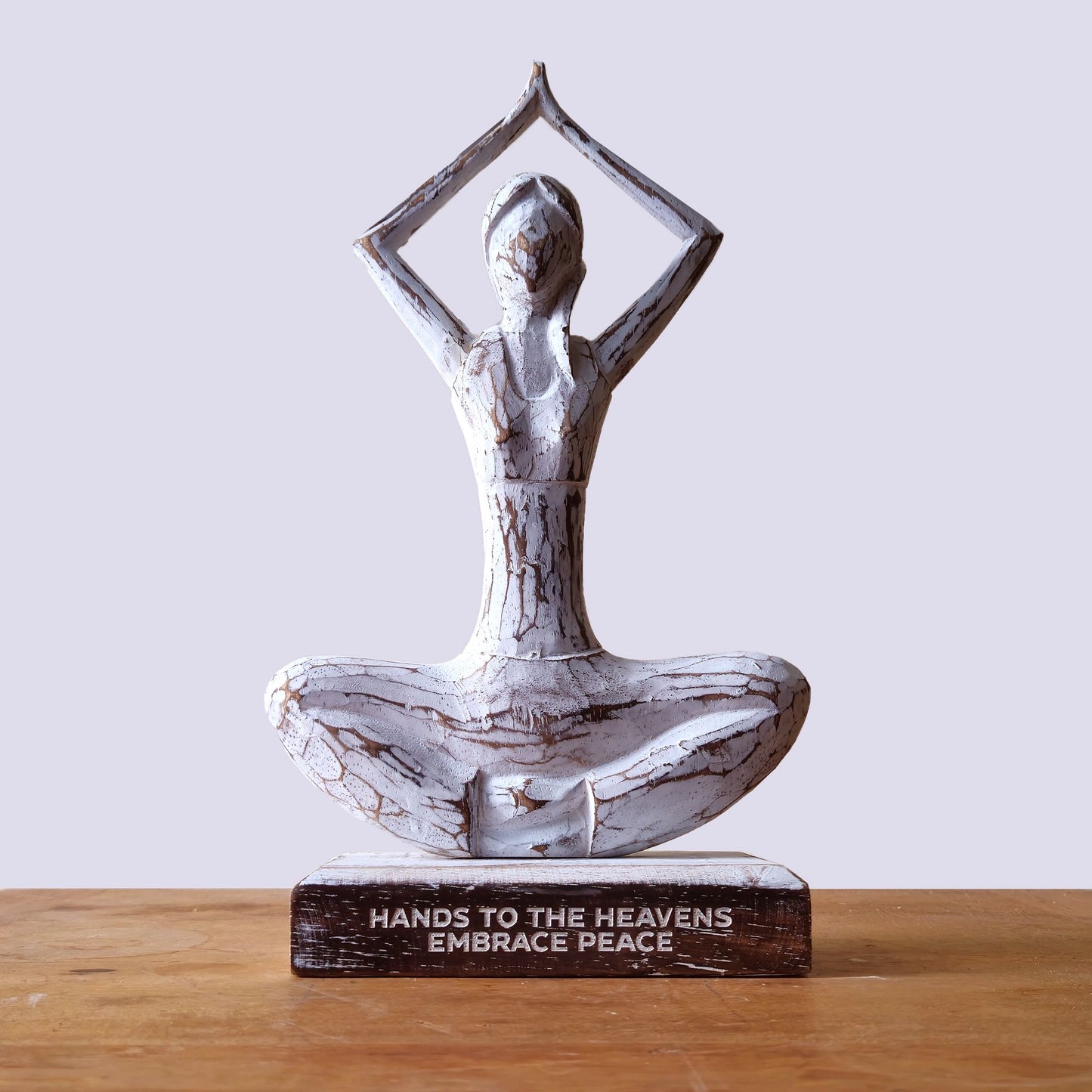Holzfigur einer Yoga-Dame in weißem Finish mit der Aufschrift „Hands to the Heavens Embrace Peace“.