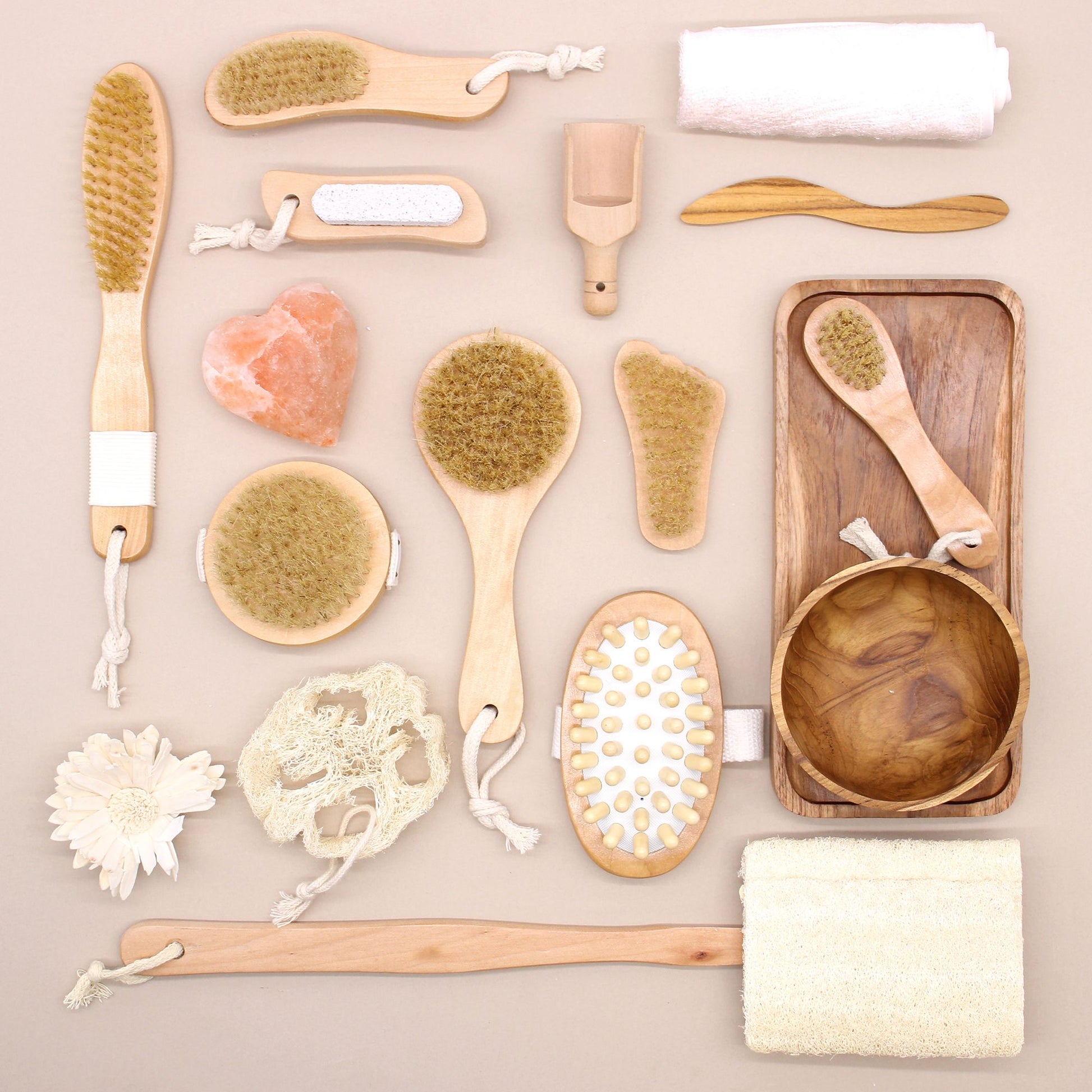 Wooden brushes, pumice stone, loofah, and a pink heart-shaped stone.