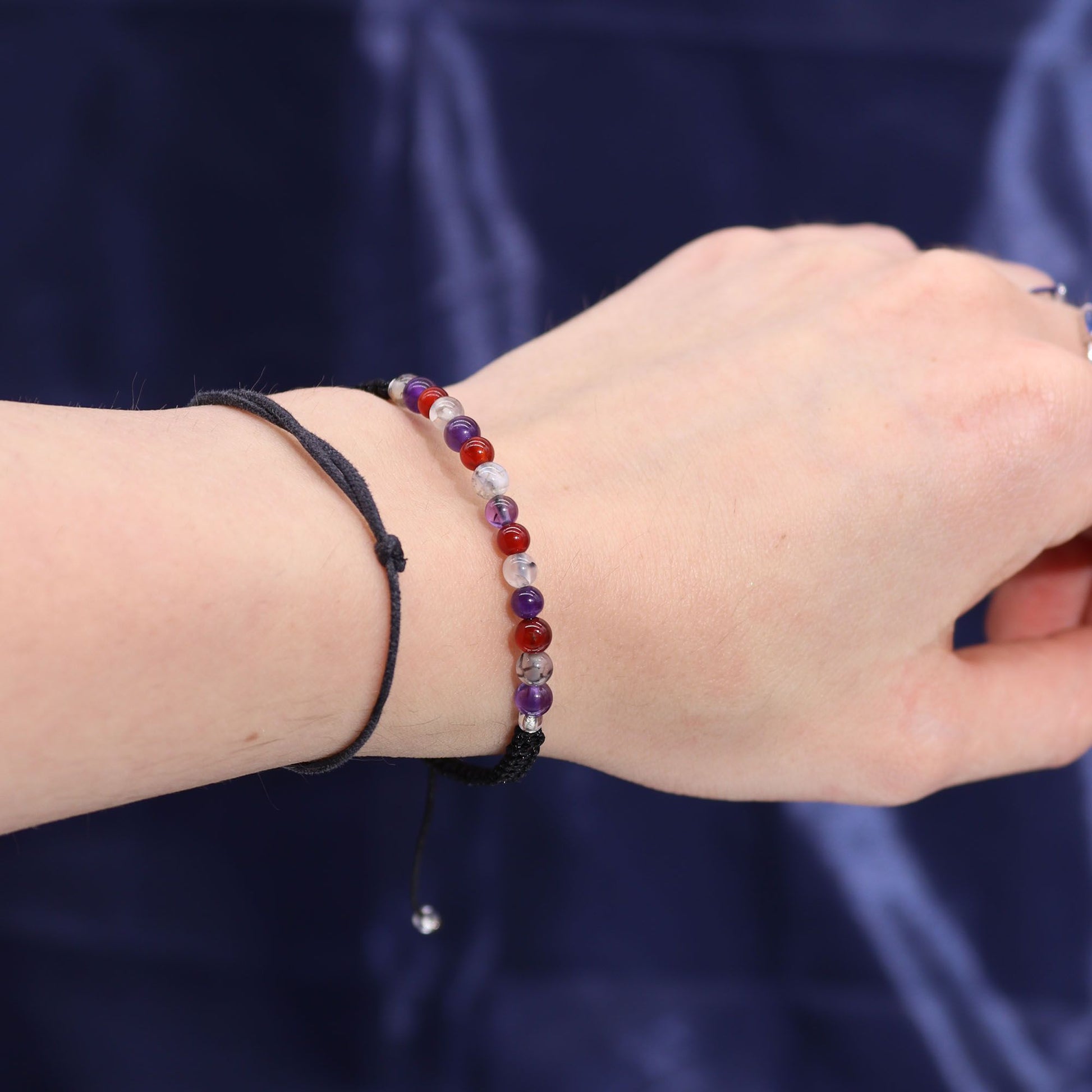 Armband mit bunten Edelsteinen und schwarzem Band.