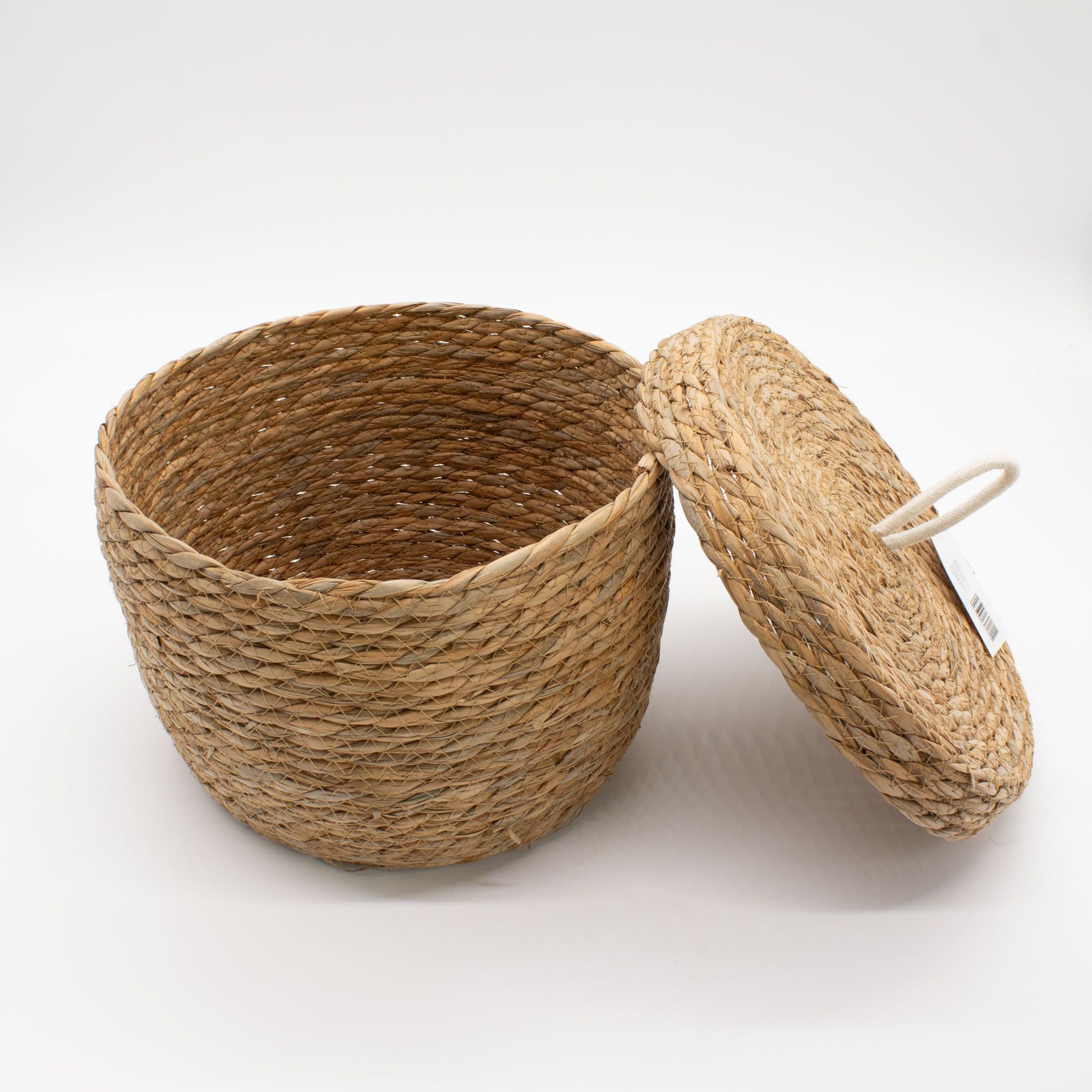 A natural seagrass basket with a lid and rope handle.