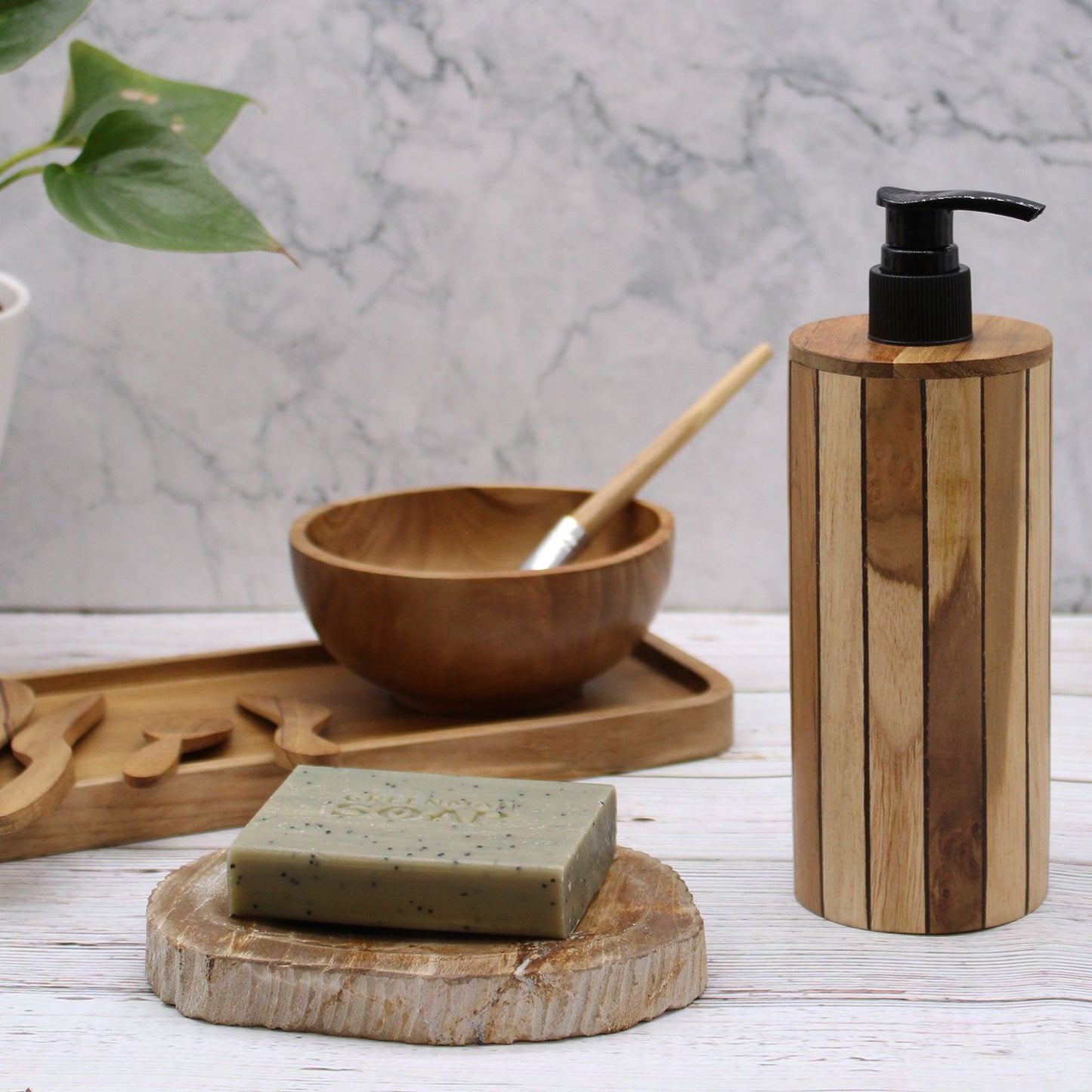 Natural teakwood soap dispenser with a black pump next to a bar of soap.
