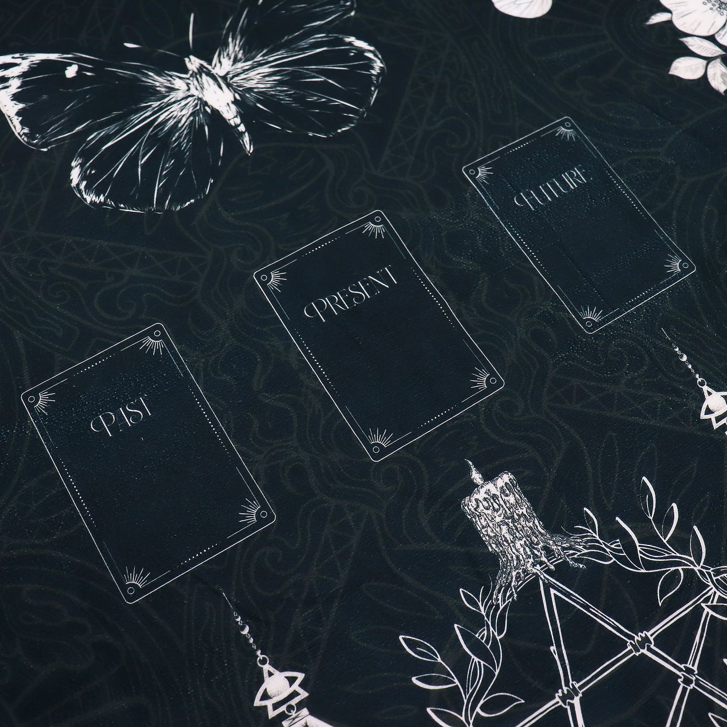 Tarot reading cloth with a butterfly, three cards labeled Past, Present, and Future, and a candle.