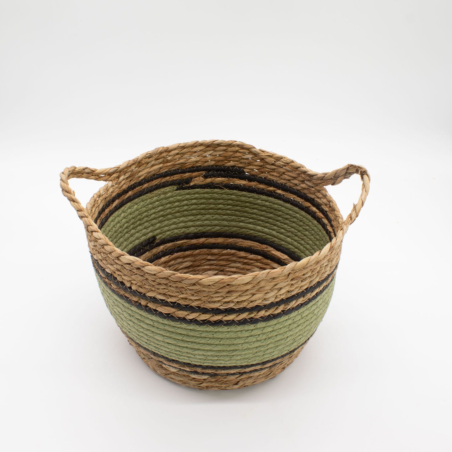 A round, woven seagrass basket with green and black stripes and handles.