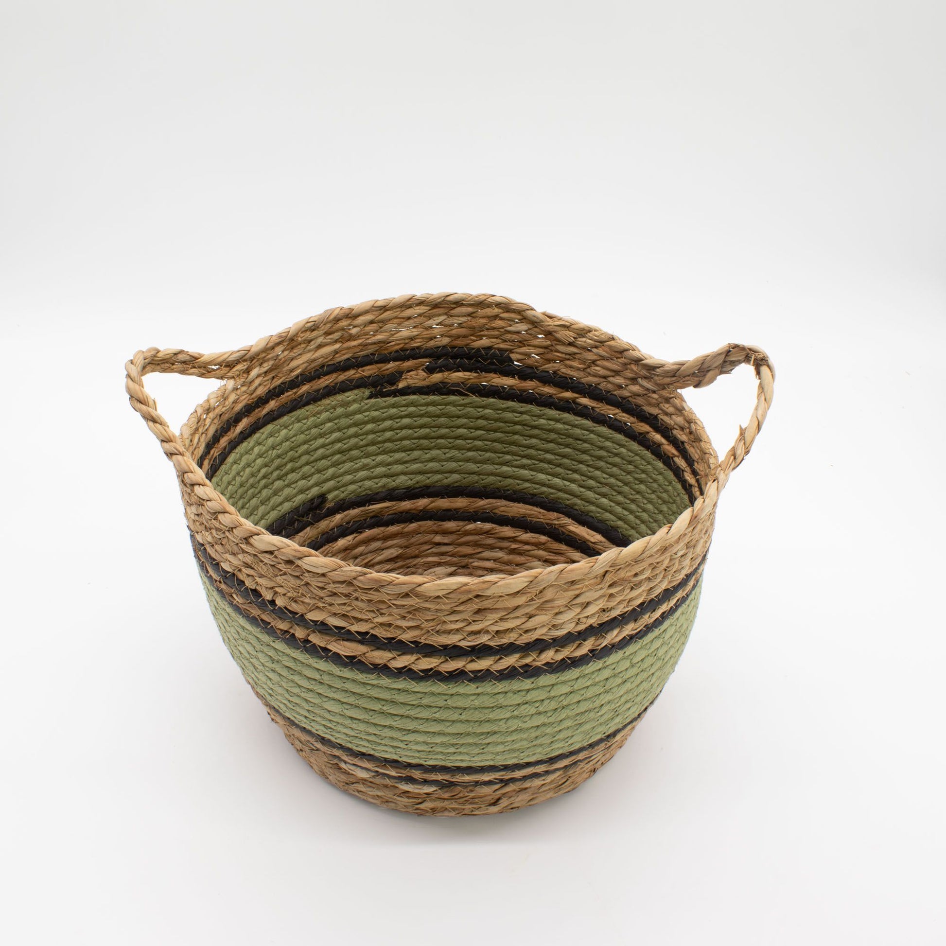 A round, woven seagrass basket with green and black stripes and handles.