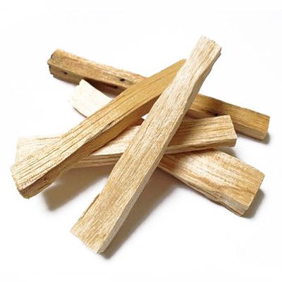 A pile of natural, light brown Palo Santo wood sticks on a white background.