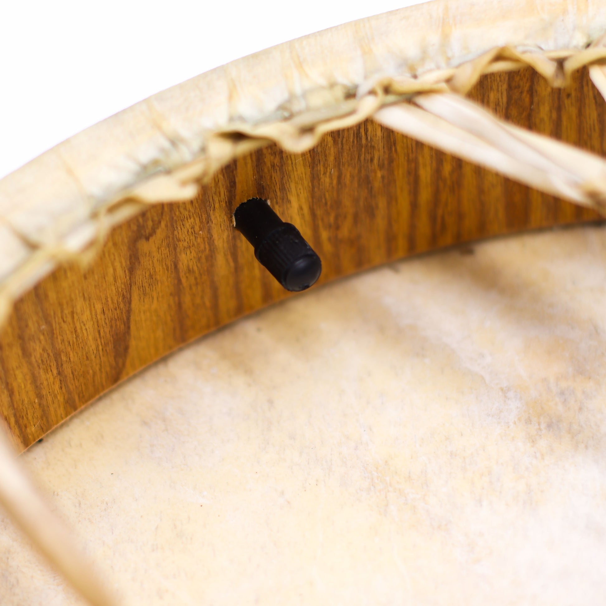 Eine schamanische Trommel mit einem schwarzen Stimmventil und Holzrand.