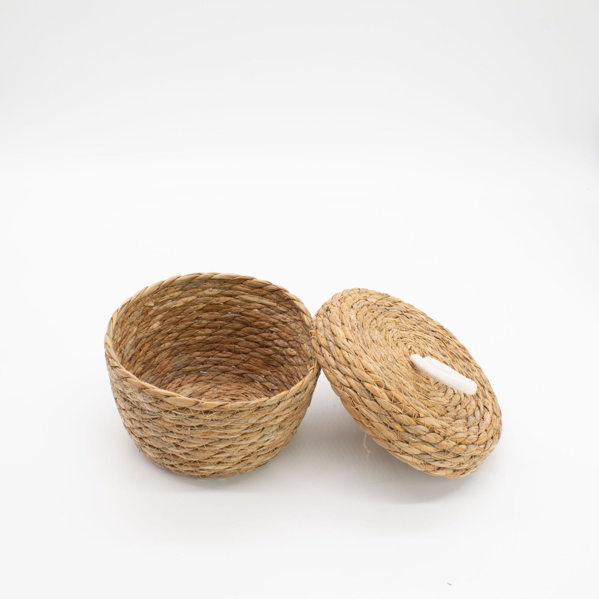 A natural seagrass basket with a lid and white cotton detail.