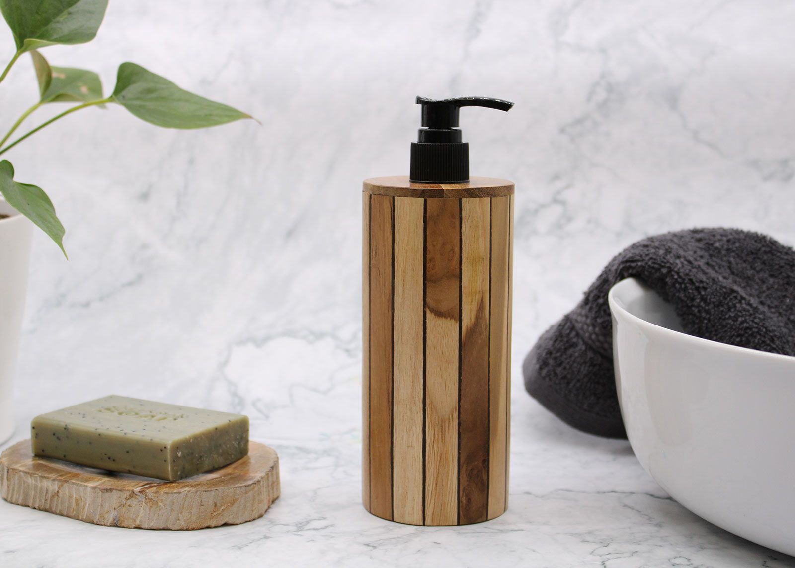 Natural teakwood soap dispenser with a black pump on a marble surface.