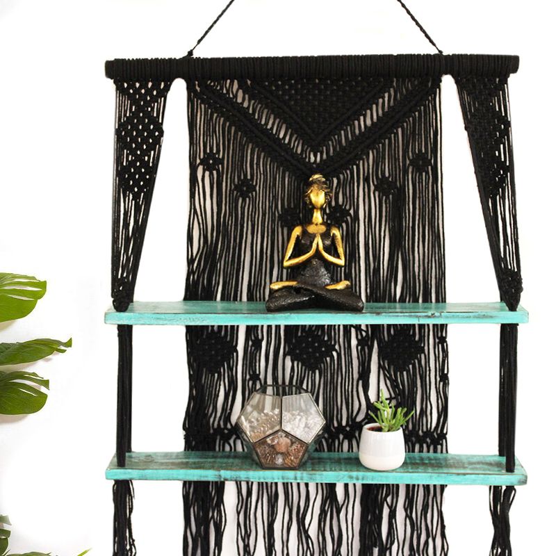 Dekoratives Makrame-Hängeregal mit zwei Holzbrettern im Boho-Stil.