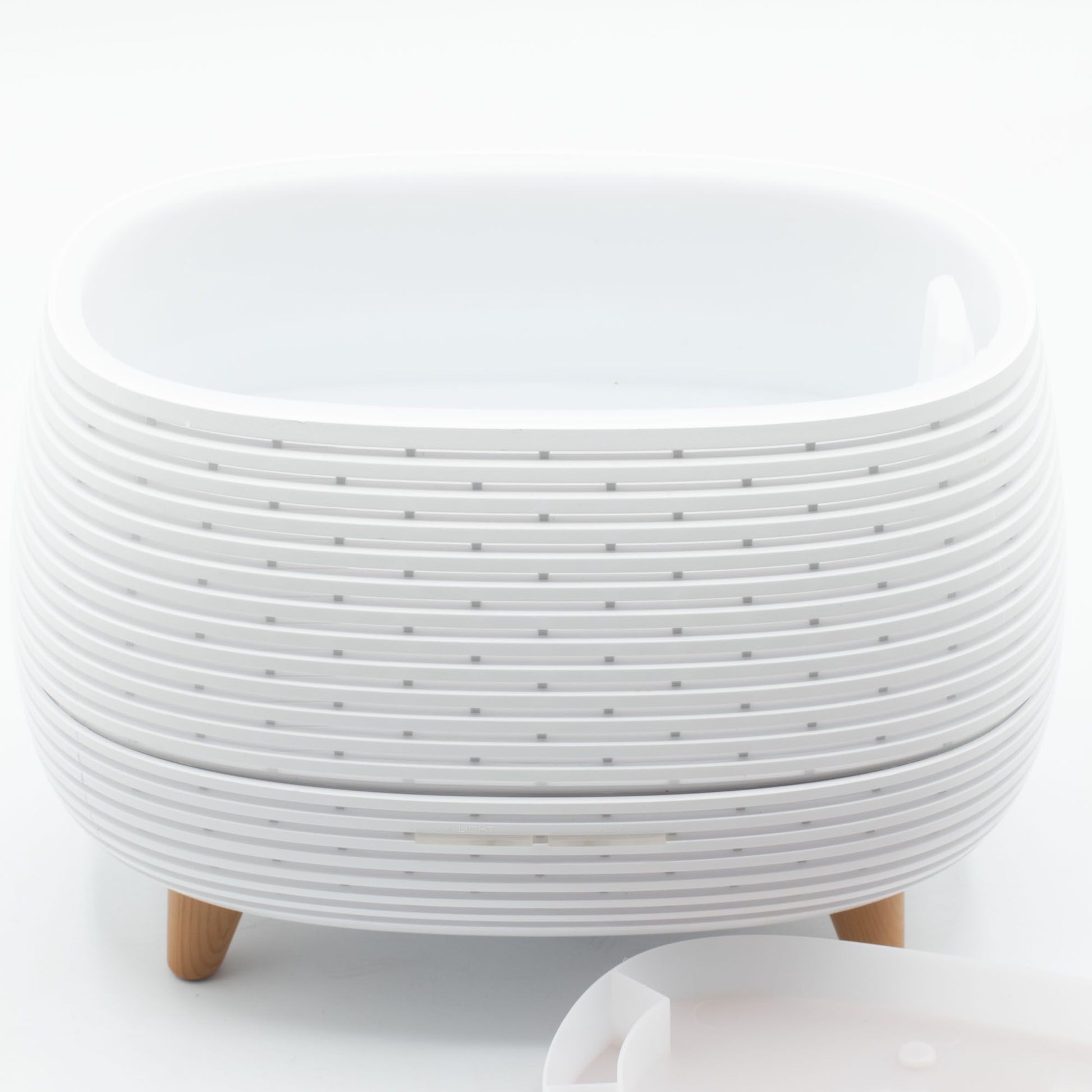 Futuristic ribbed aroma diffuser with color-changing light and wooden legs.
