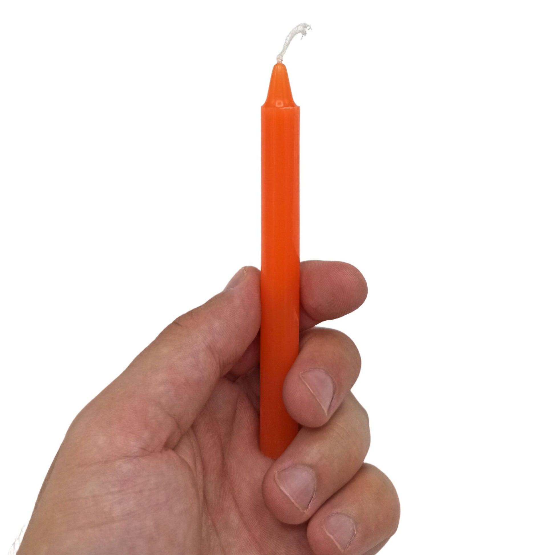 Eine orangefarbene Kerze wird von einer Hand gehalten.