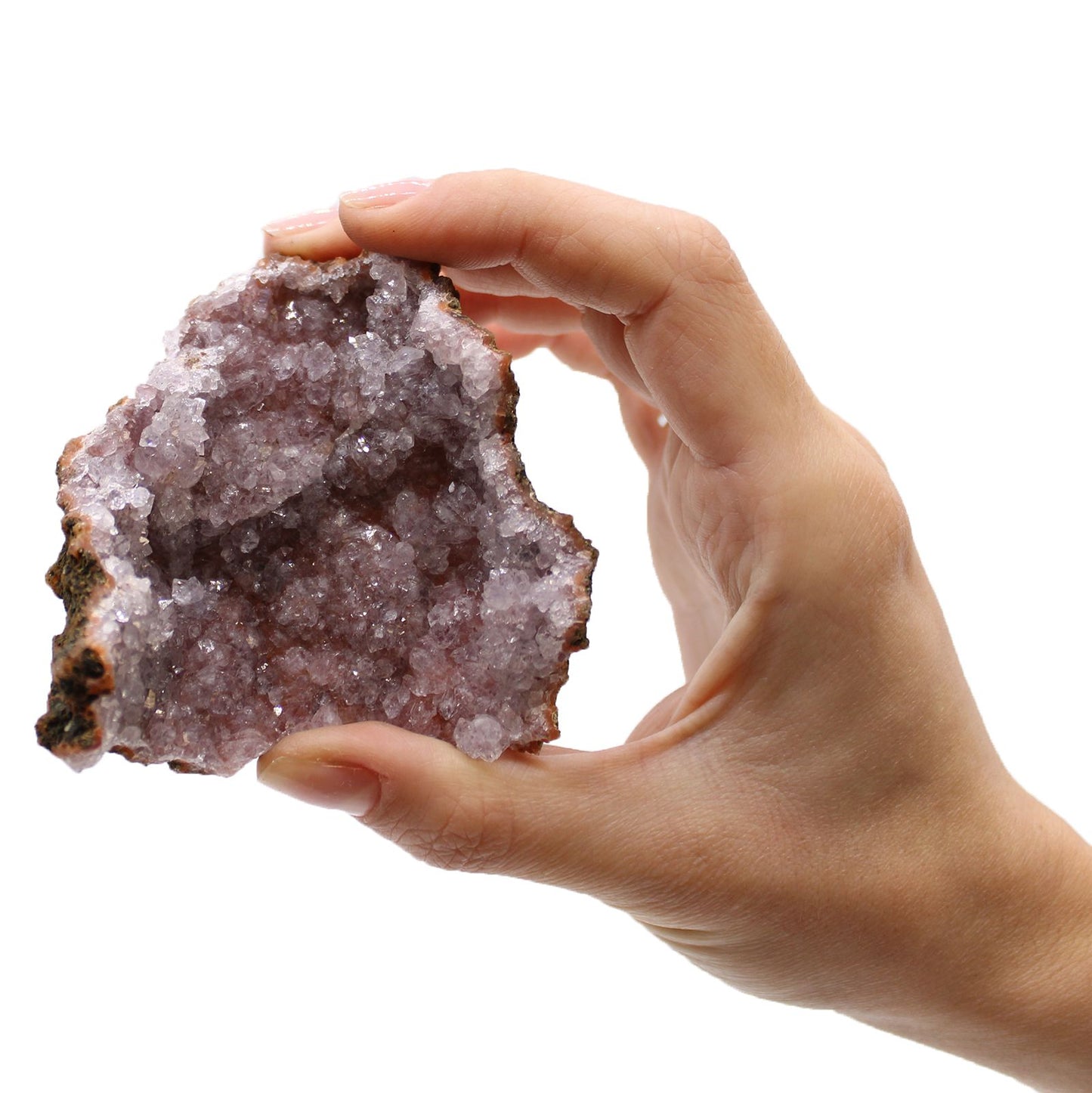 Eine Hand hält einen rohen Amethyst-Geoden-Stein mit violetten Kristallen.