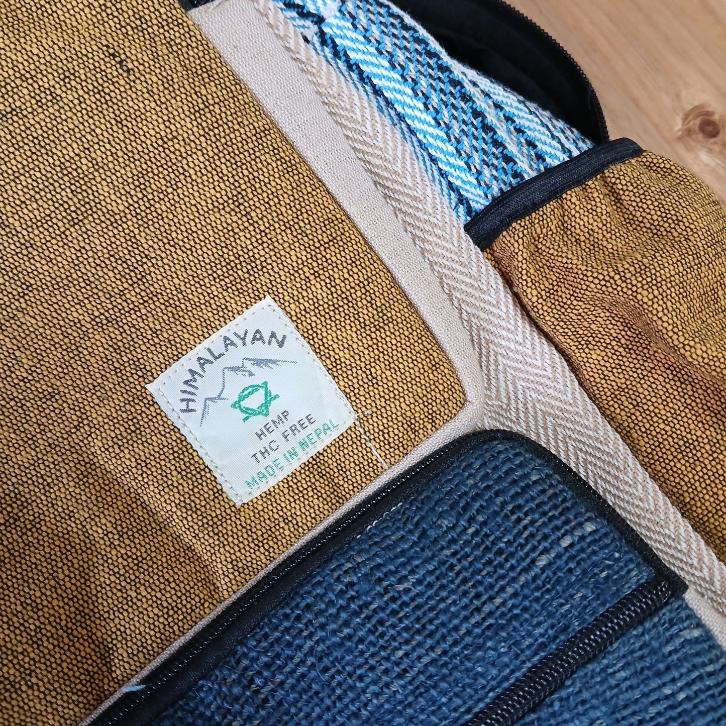 Großer Hanfrucksack in Teal & Tumeric mit Etikett aus Nepal.