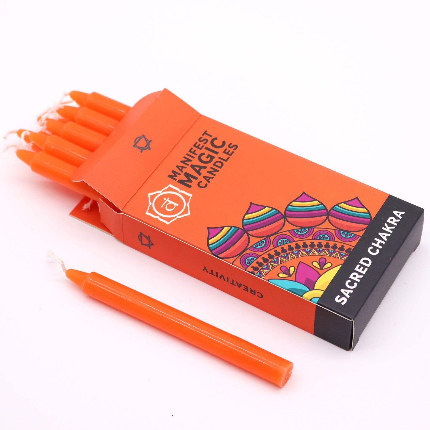 Orange Manifestationskerzen im Sacral Chakra Design, eine Kerze liegt davor.