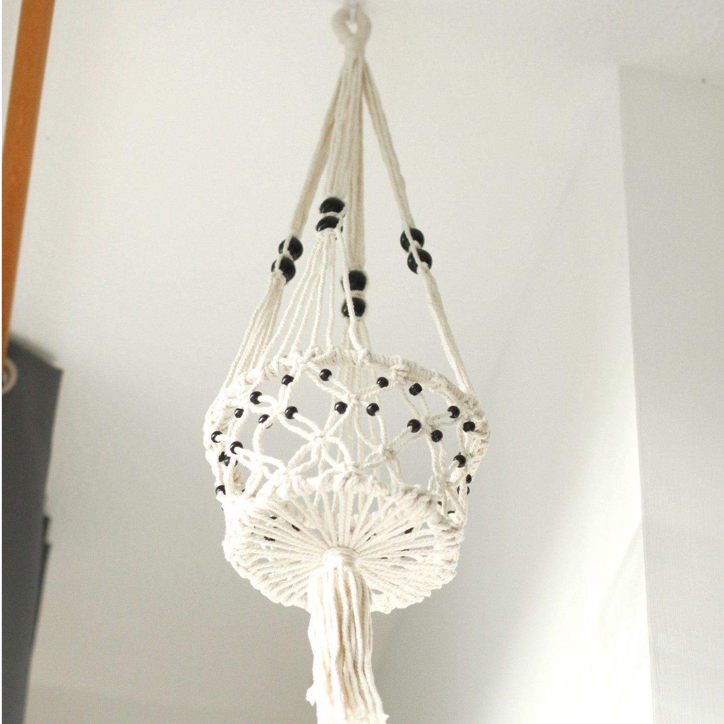 Makramee-Blumentopfhalter mit schwarzen Perlen.