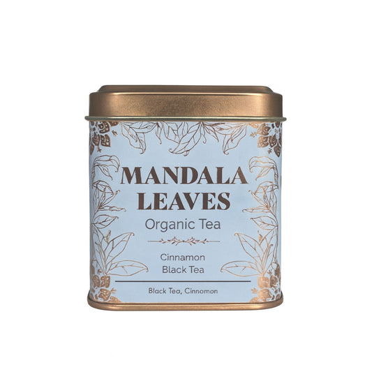 A light blue tin of Mandala Leaves Organic Cinnamon Black Tea with gold leaf accents.