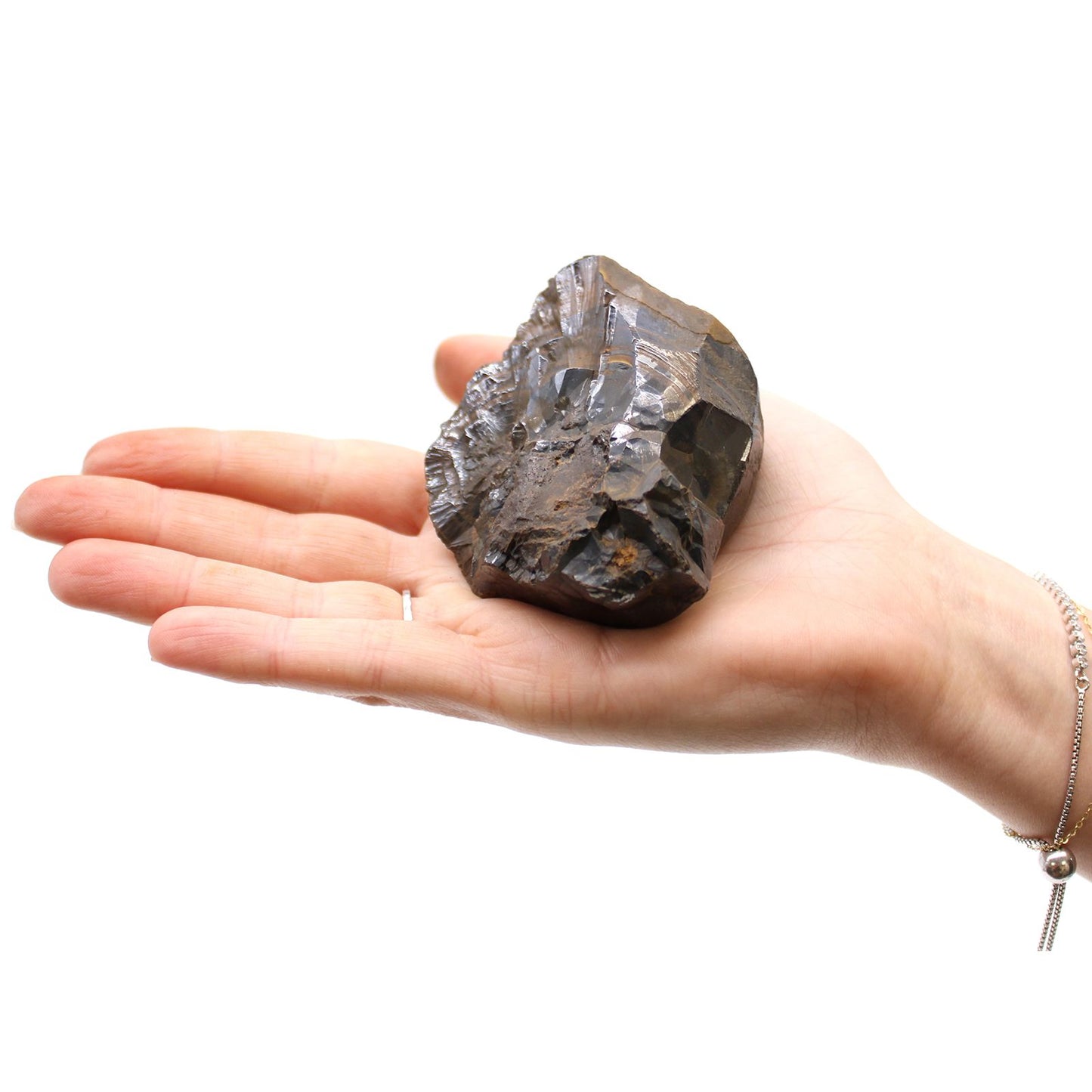 Natürlicher Hämatit Rohstein mit metallischem Glanz auf einer Hand.