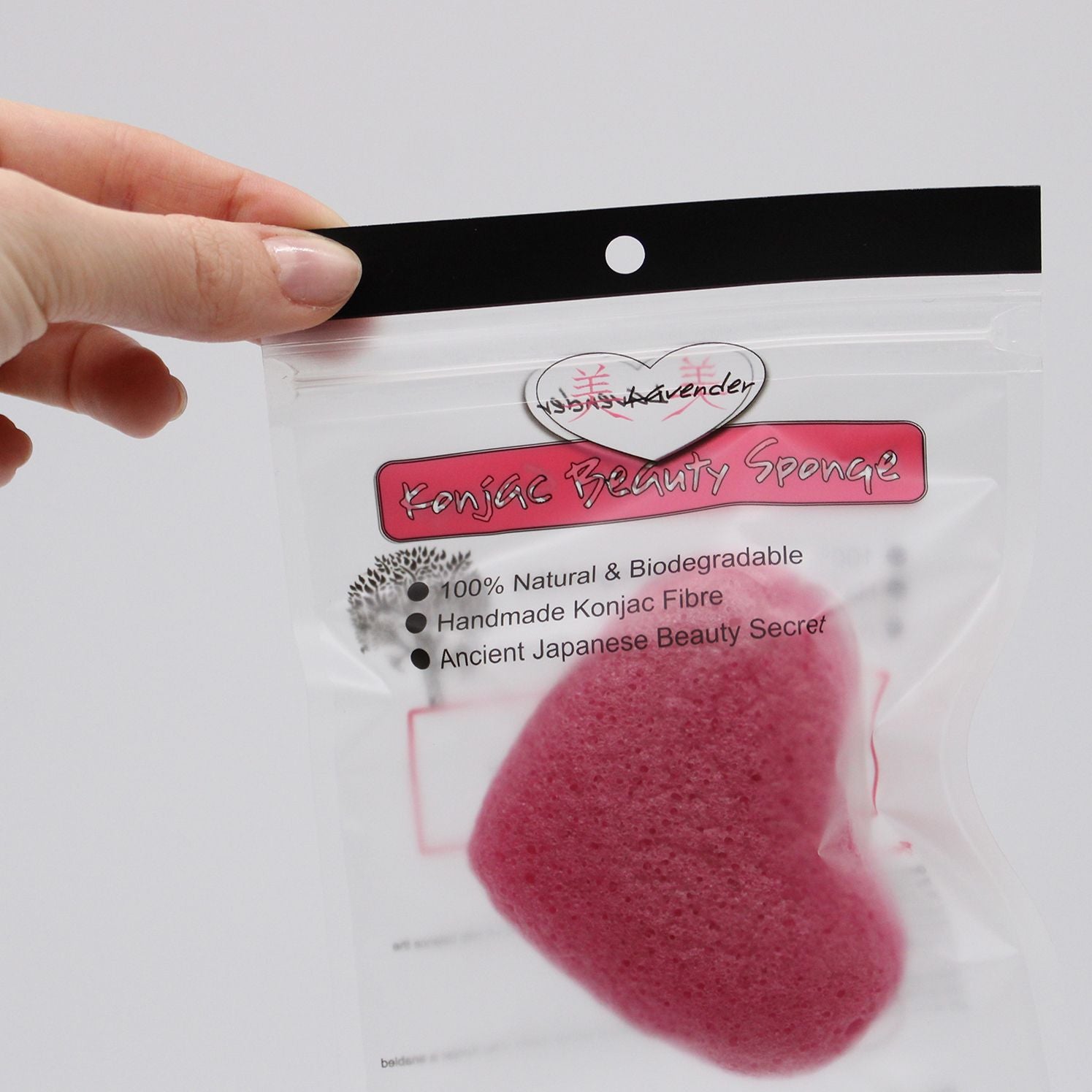 A pink heart-shaped konjac sponge in packaging.