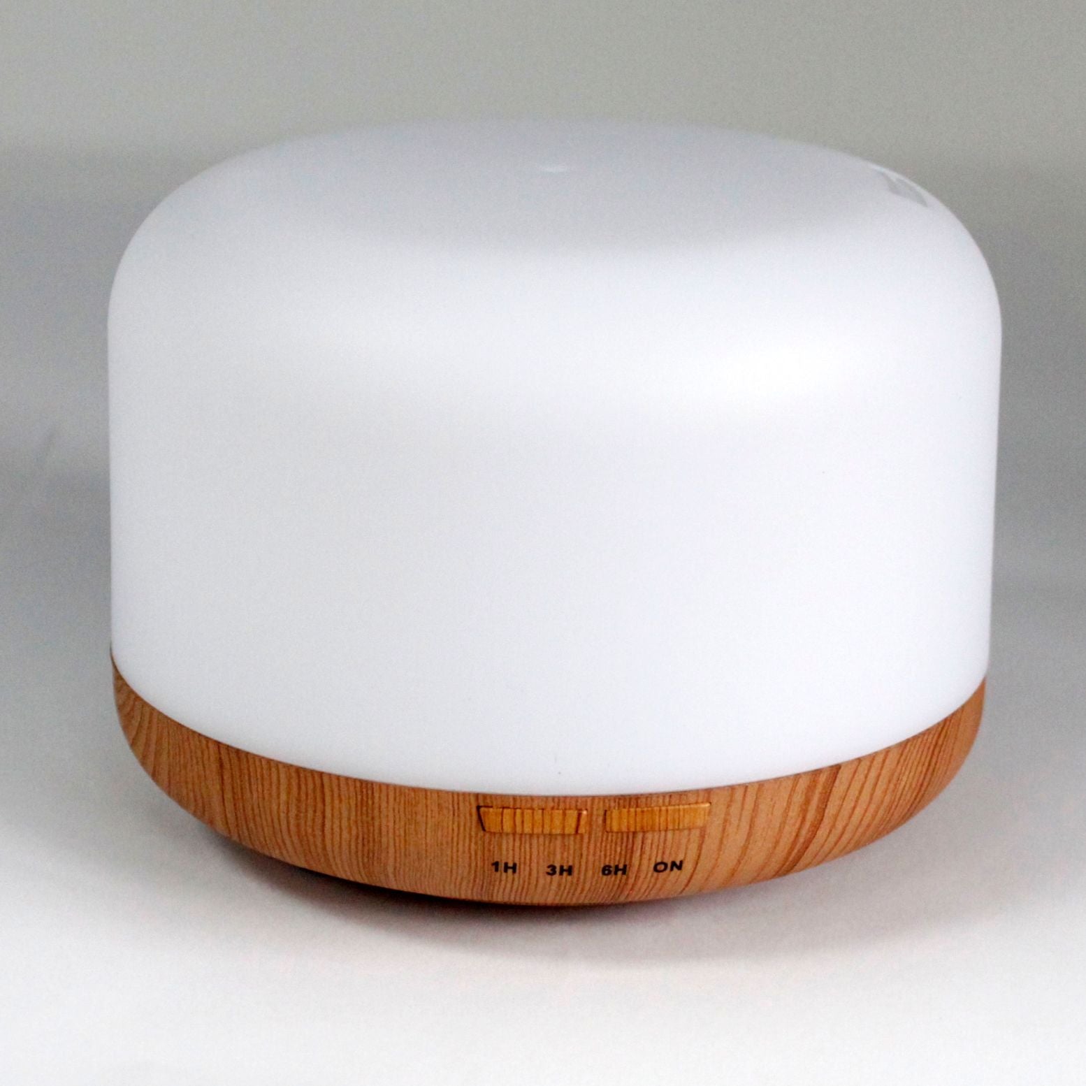 A white pod-shaped aroma diffuser with a wood-grain base and timer buttons.