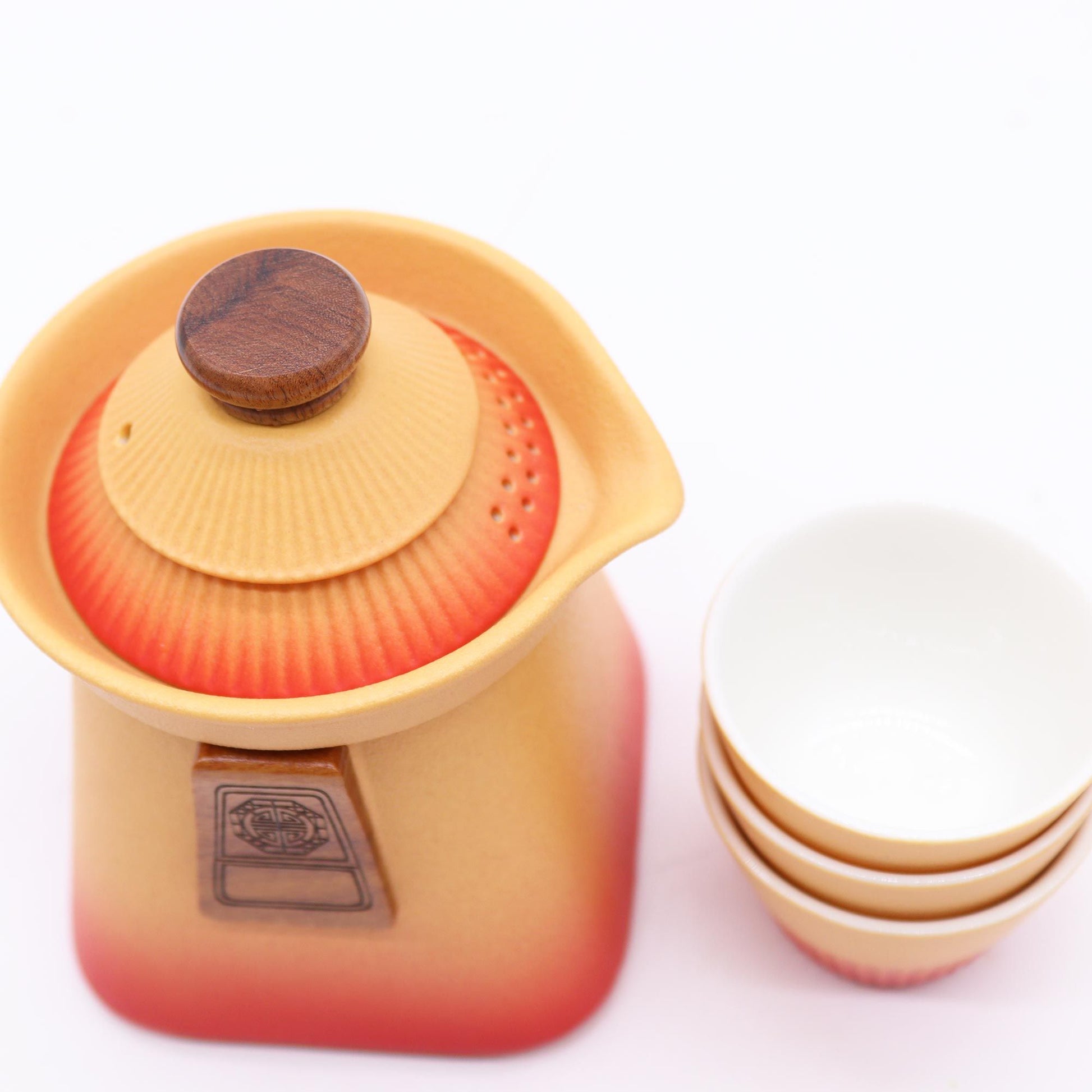 Orange earth ceramic teapot with wooden lid and three matching cups.
