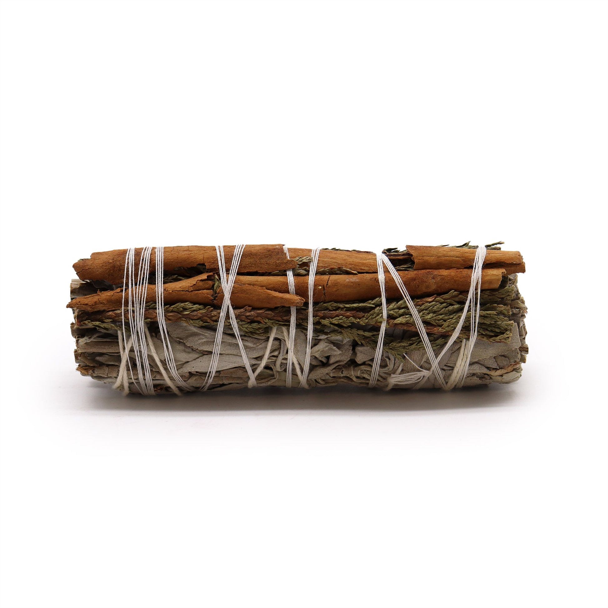 Smudge stick bundle of white sage, cedar, and cinnamon sticks tied with white string.