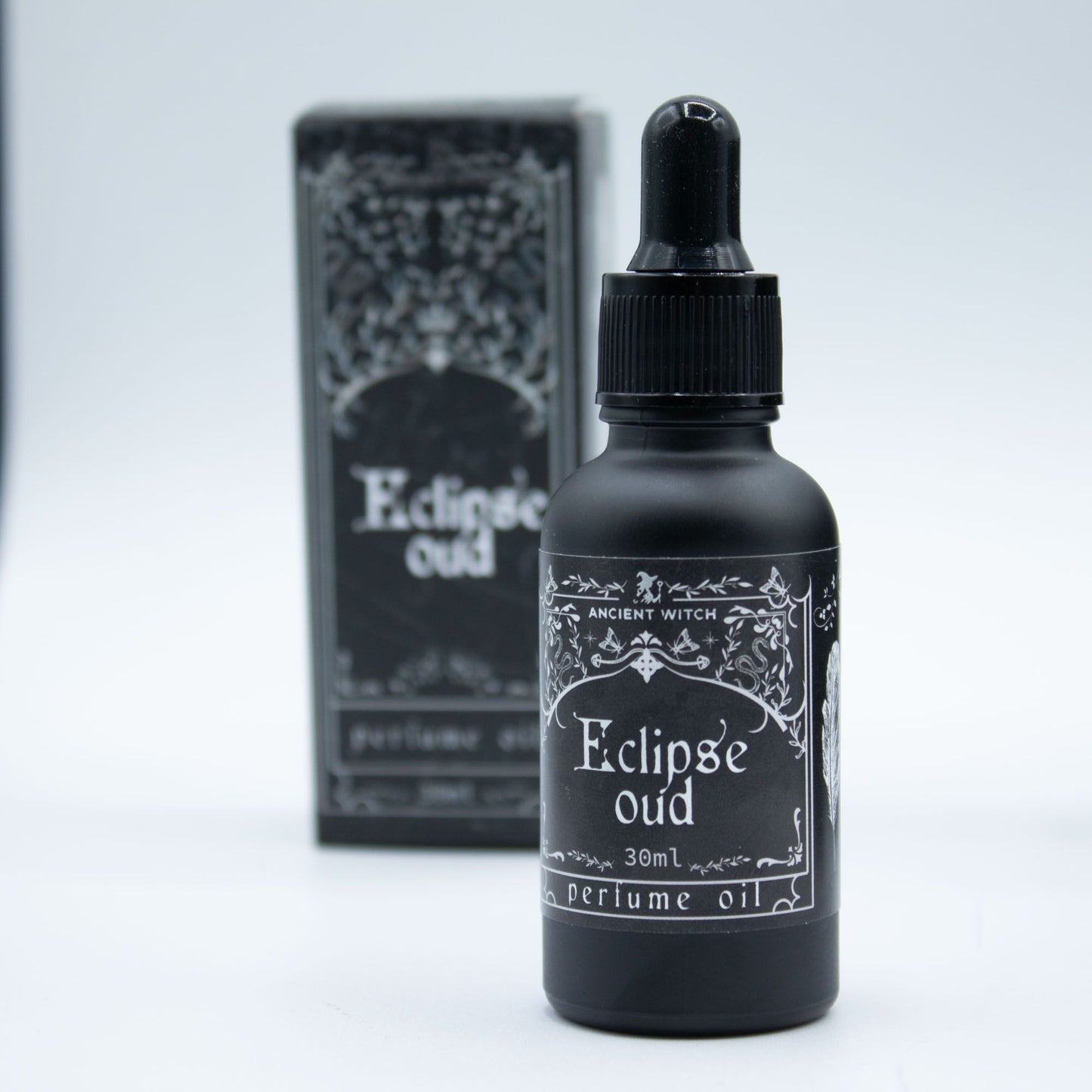 Black bottle of Eclipse Oud perfume oil with dropper and box.