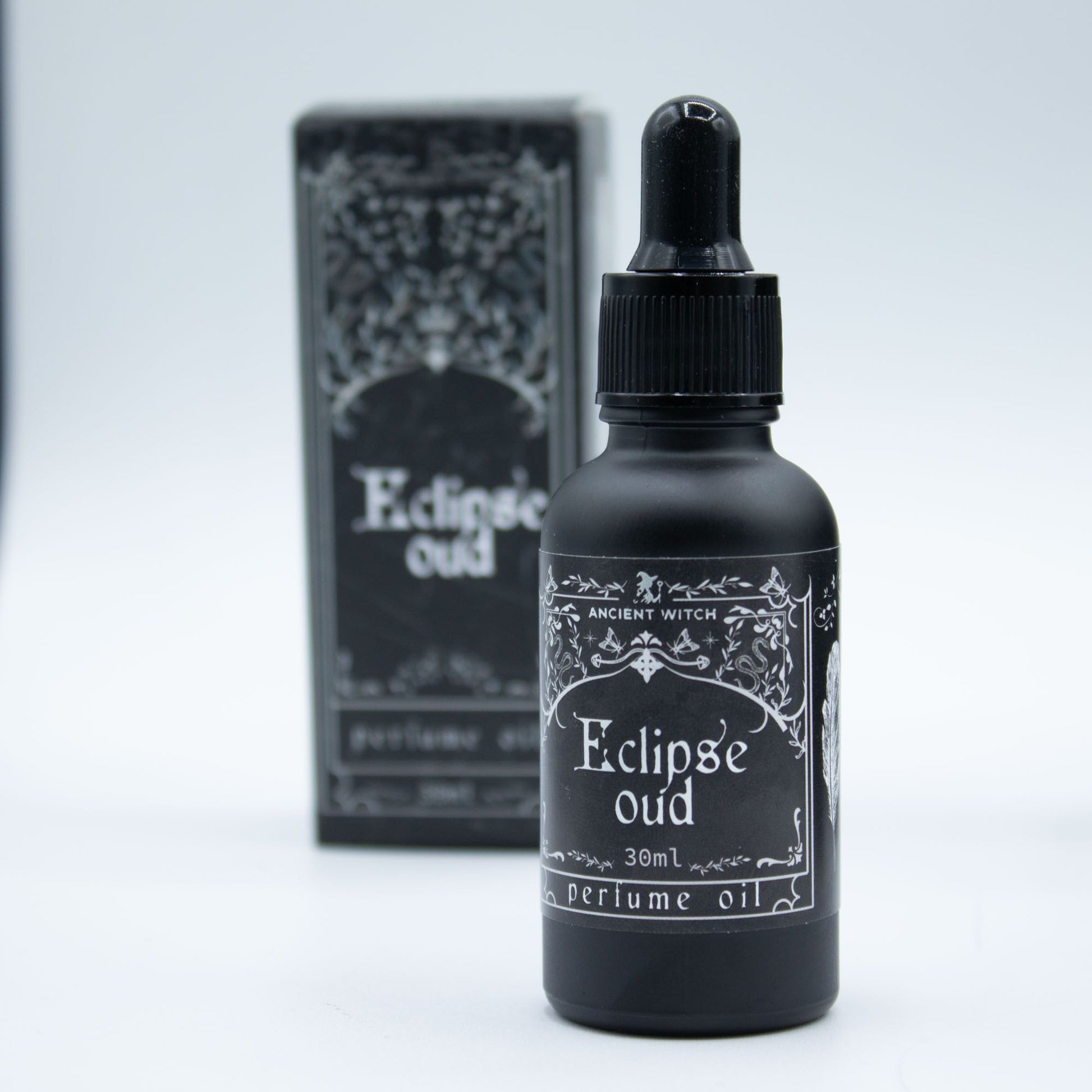 Black bottle of Eclipse Oud perfume oil with dropper and box.