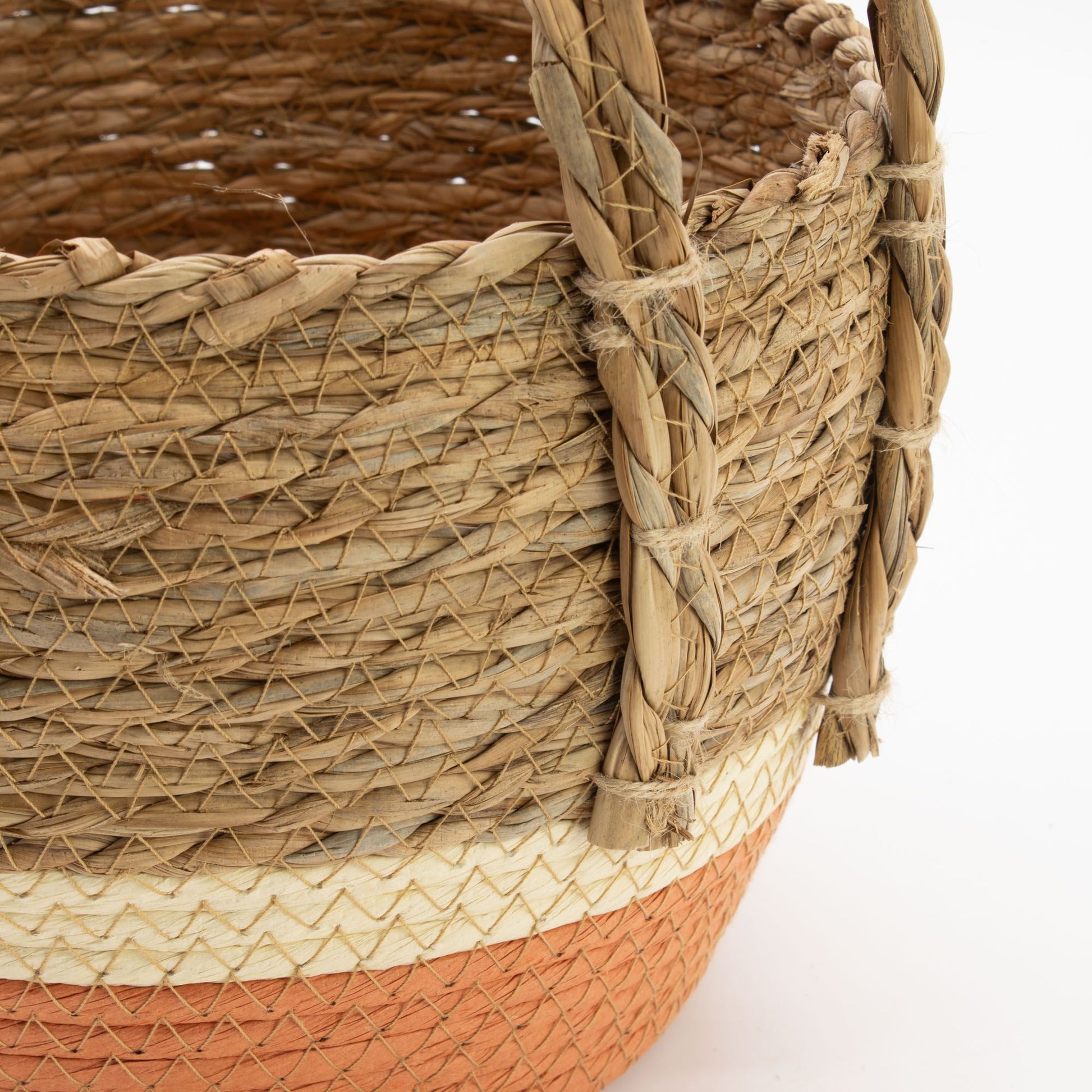 A woven straw and seagrass basket with natural and orange sections.