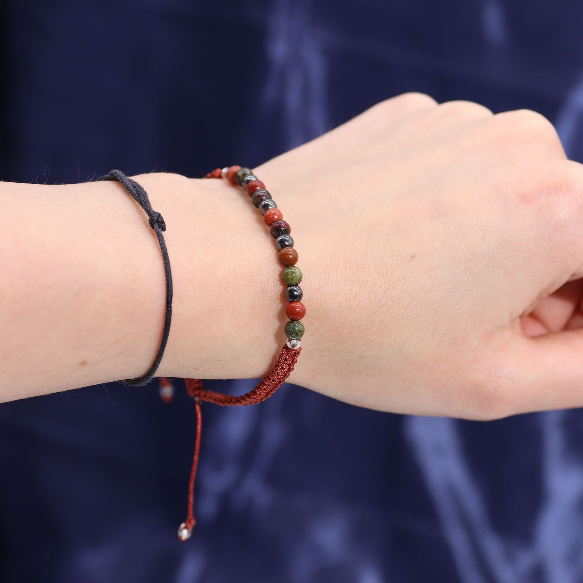 Armband mit roten und grünen Perlen und einem schwarzen Band.