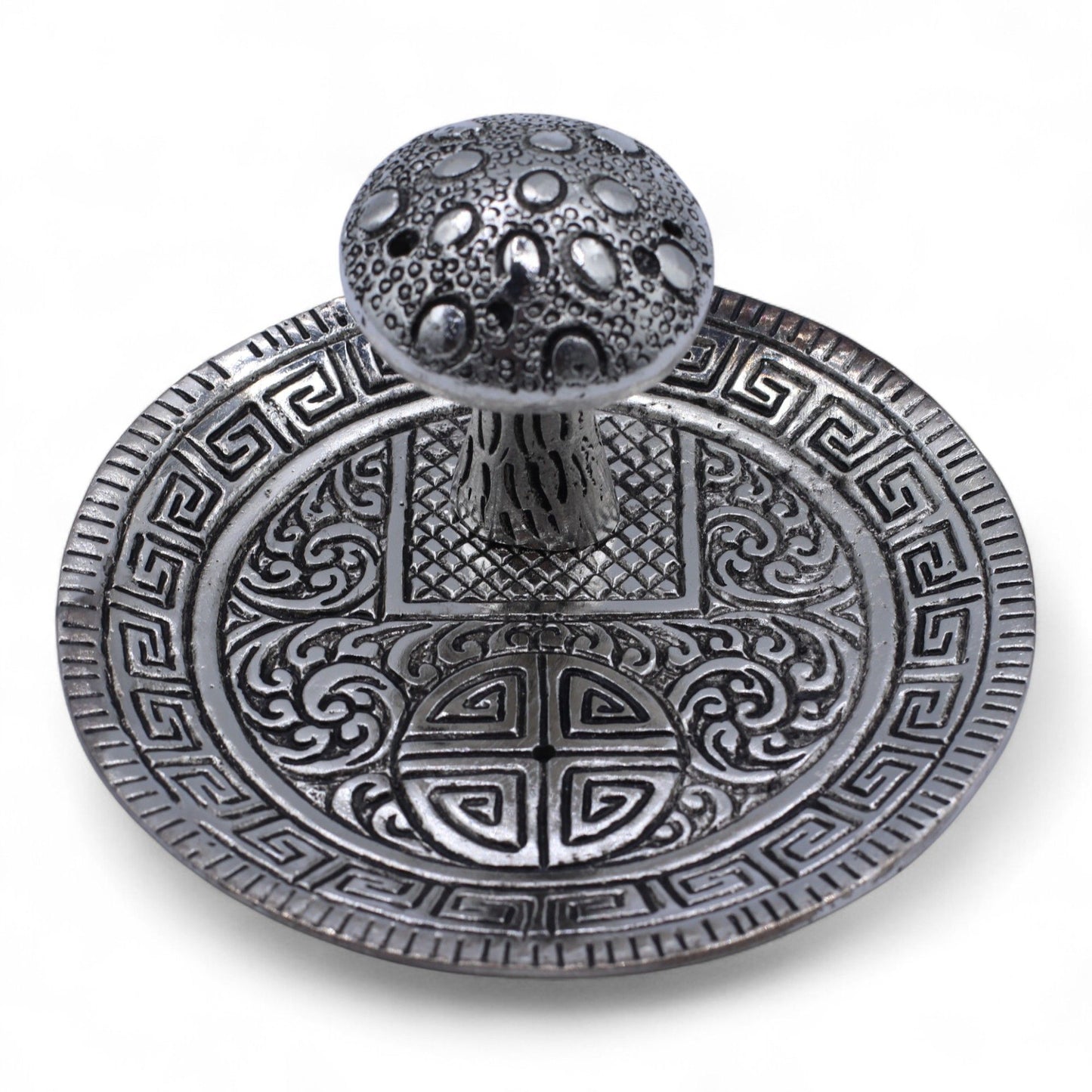 Silver effect mushroom incense holder with intricate patterns.