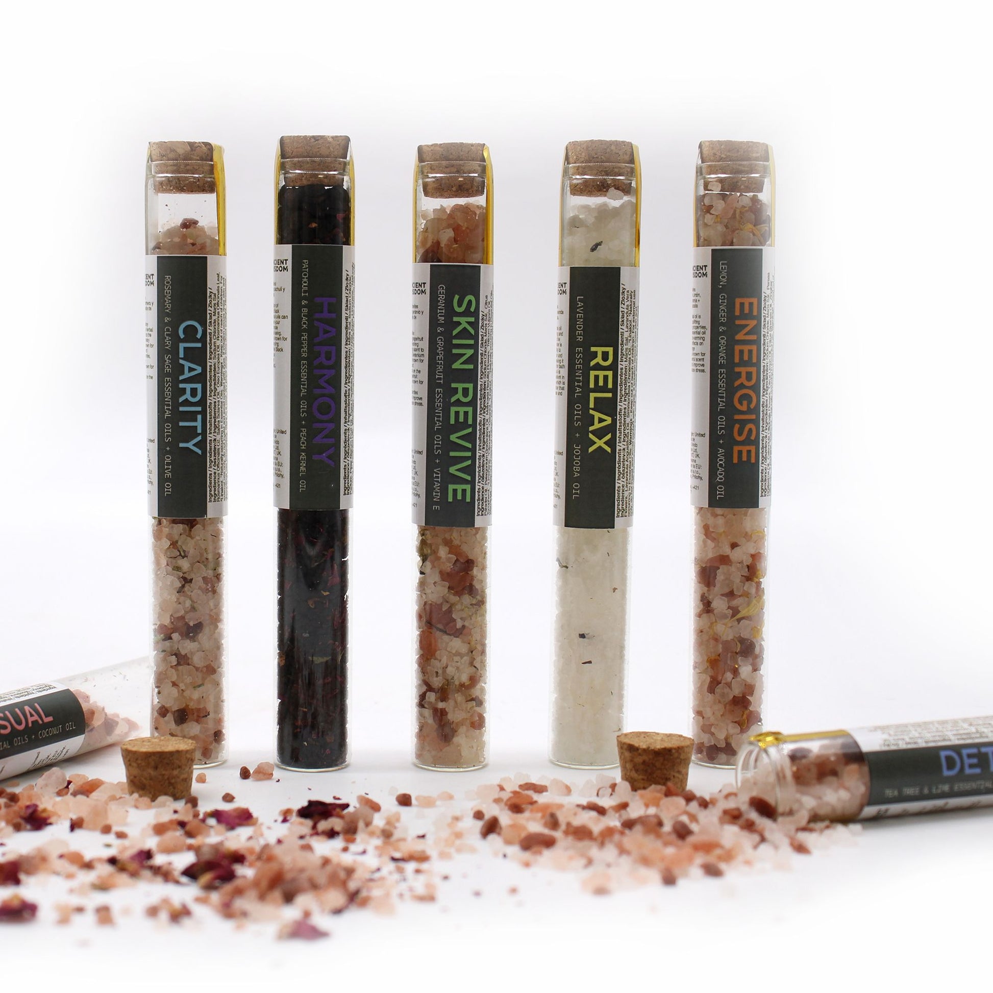 Seven glass vials of bath salts with cork stoppers and labels.