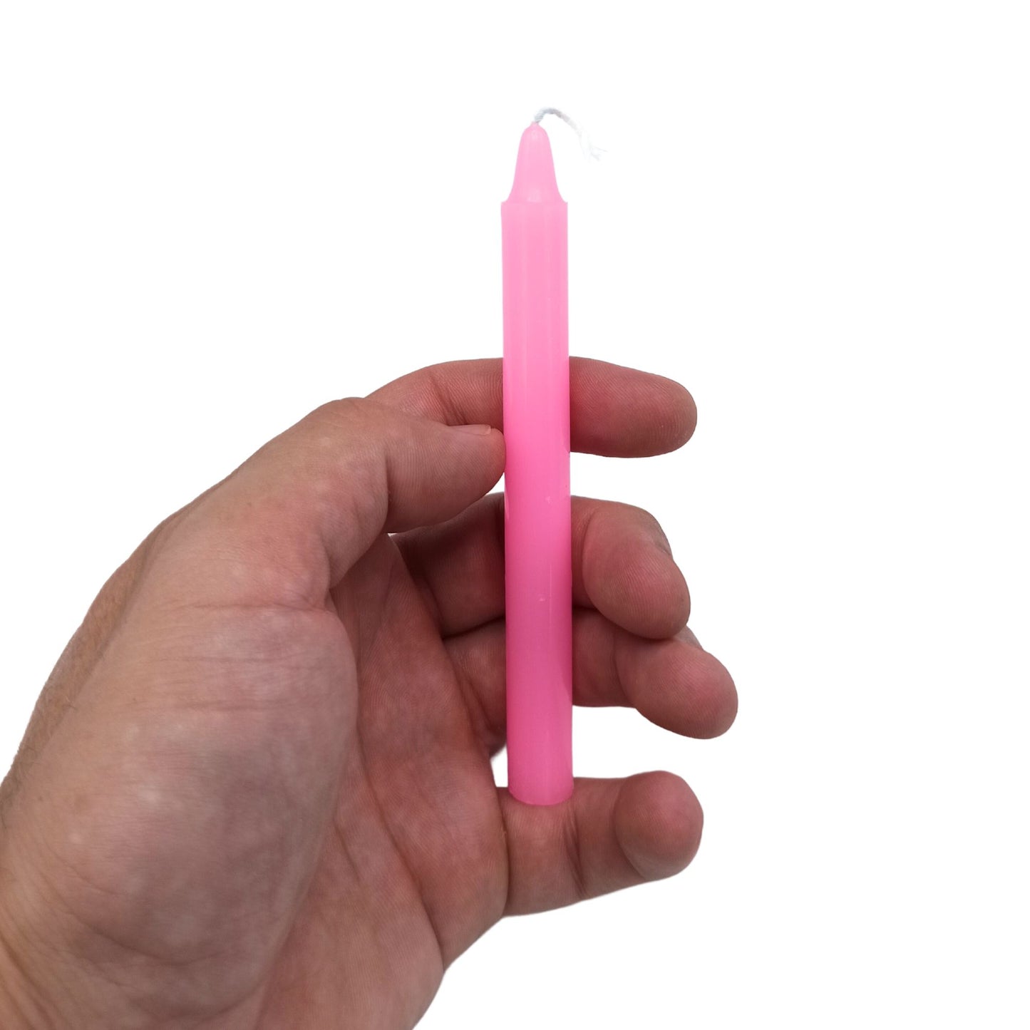 Eine pinke Ritualkerze wird in einer Hand gehalten.