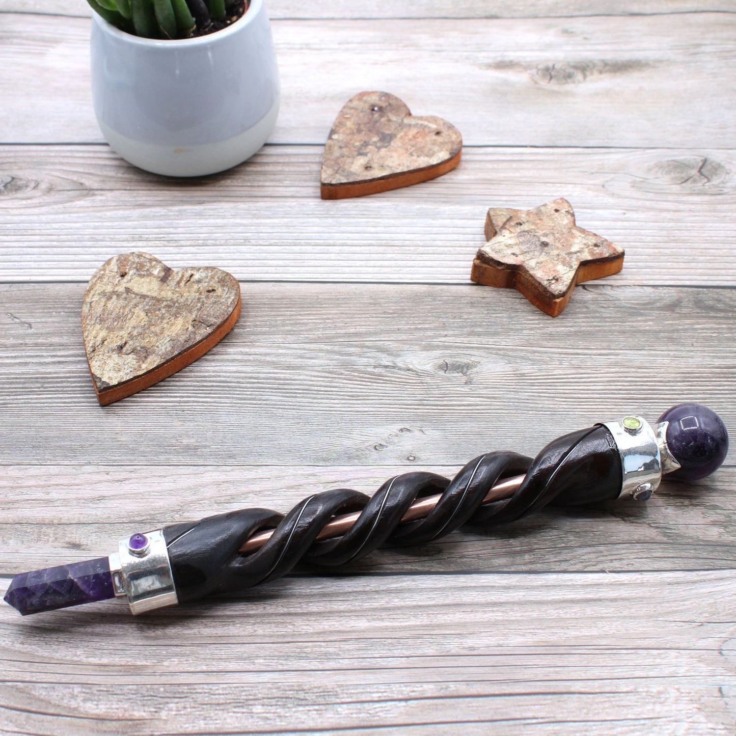 Spiral carving healing wand with copper pipe and amethyst crystals.