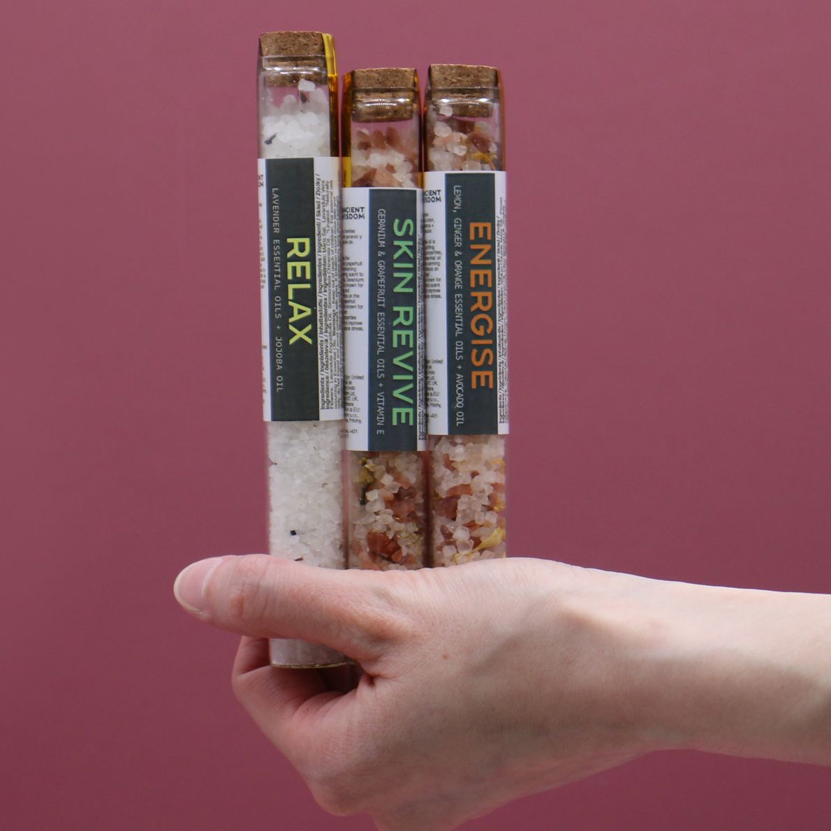 Three glass vials of bath salts labeled Relax, Skin Revive, and Energise.