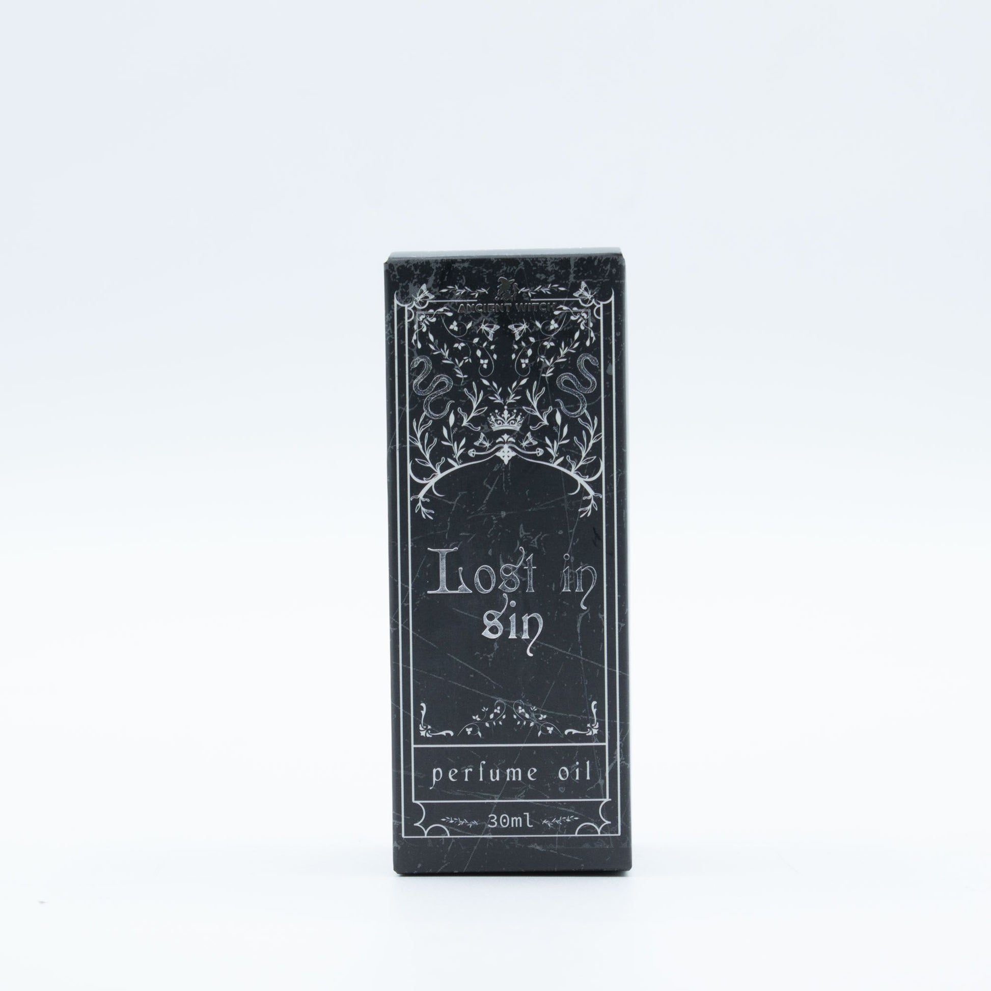 A black box with "Lost in Sin perfume oil 30ml" and ornate designs.