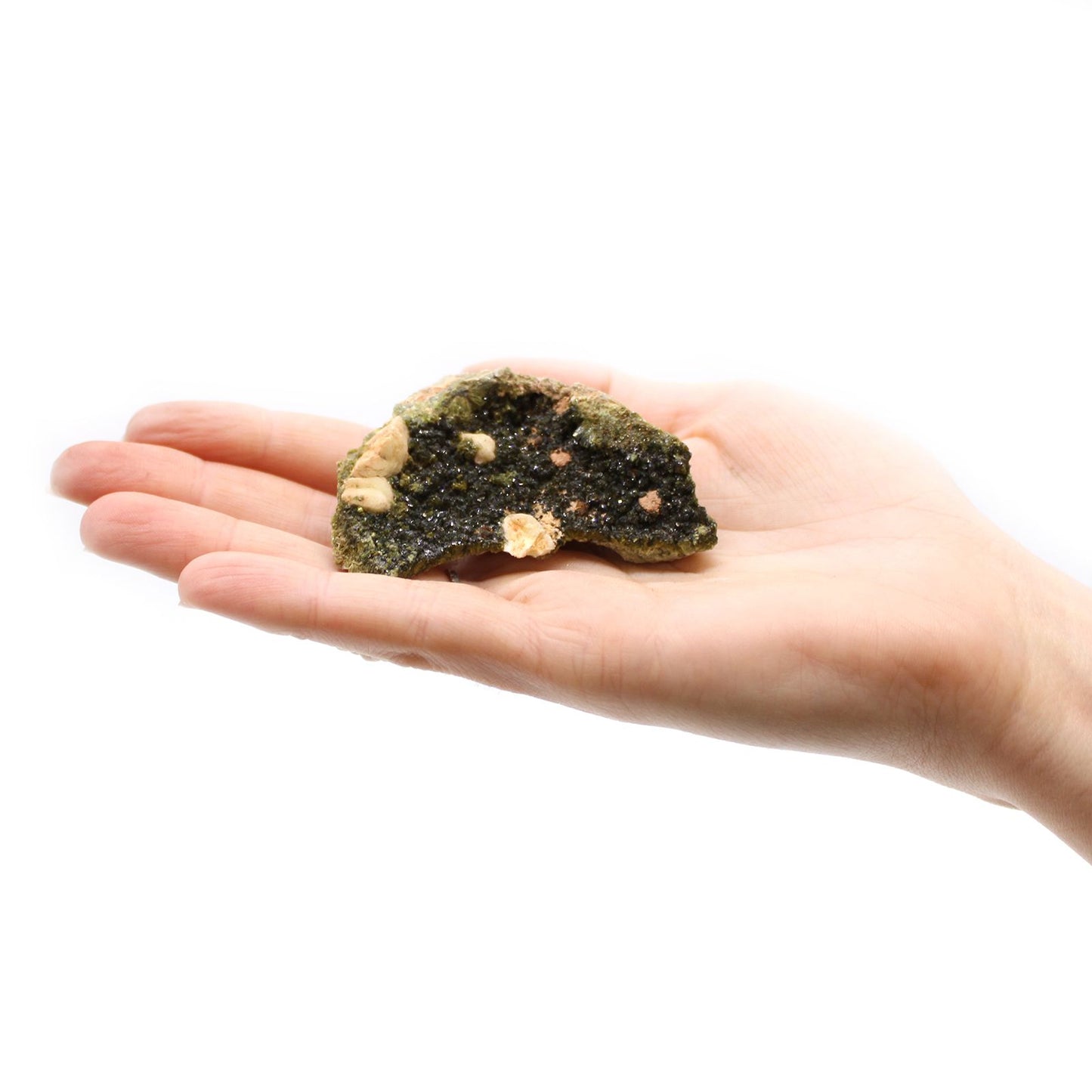 Eine Hand hält ein Stück rohen, dunkelgrünen Epidot mit helleren Einschlüssen.