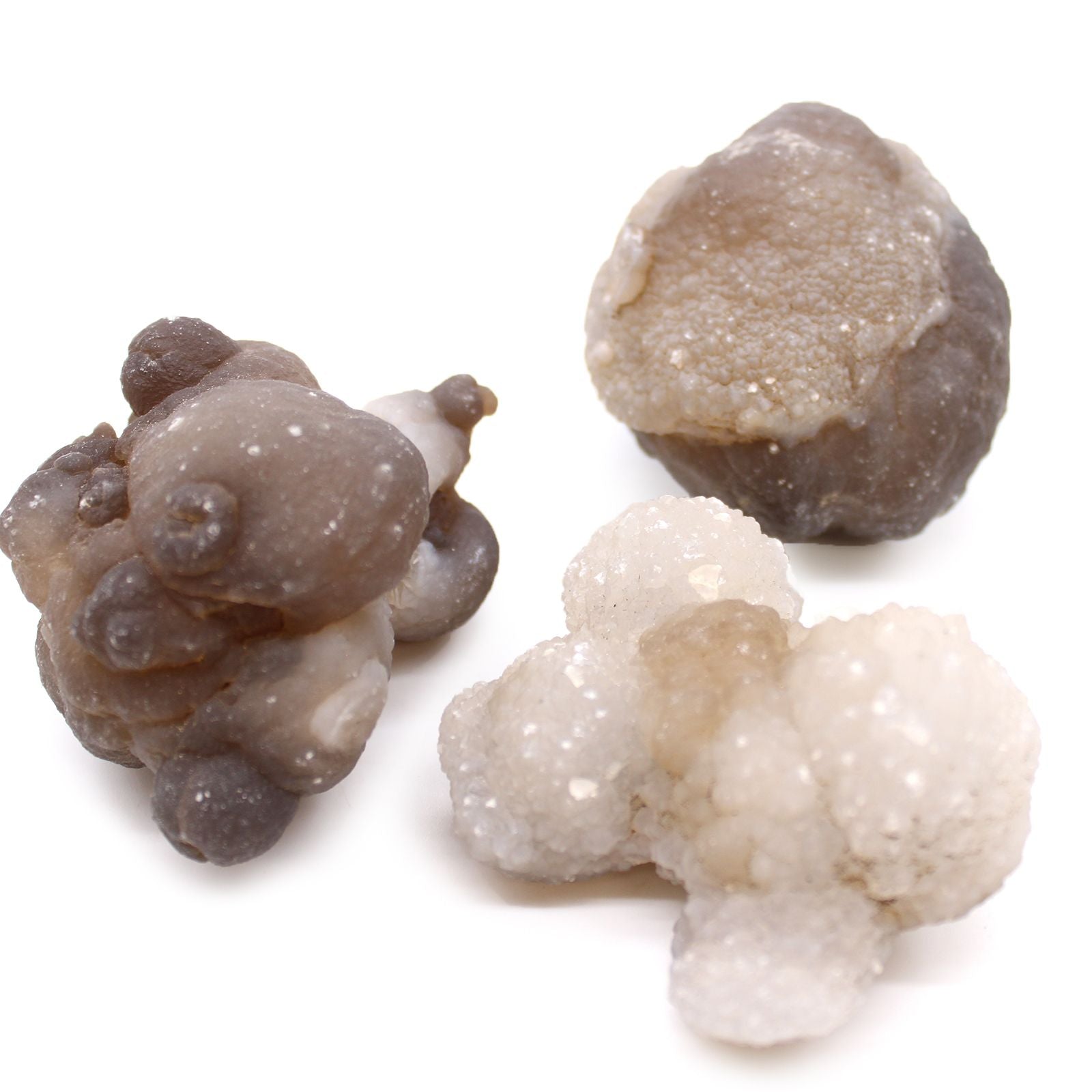 Drei rohe Chalcedon-Kristalle in verschiedenen Grau- und Weißtönen.