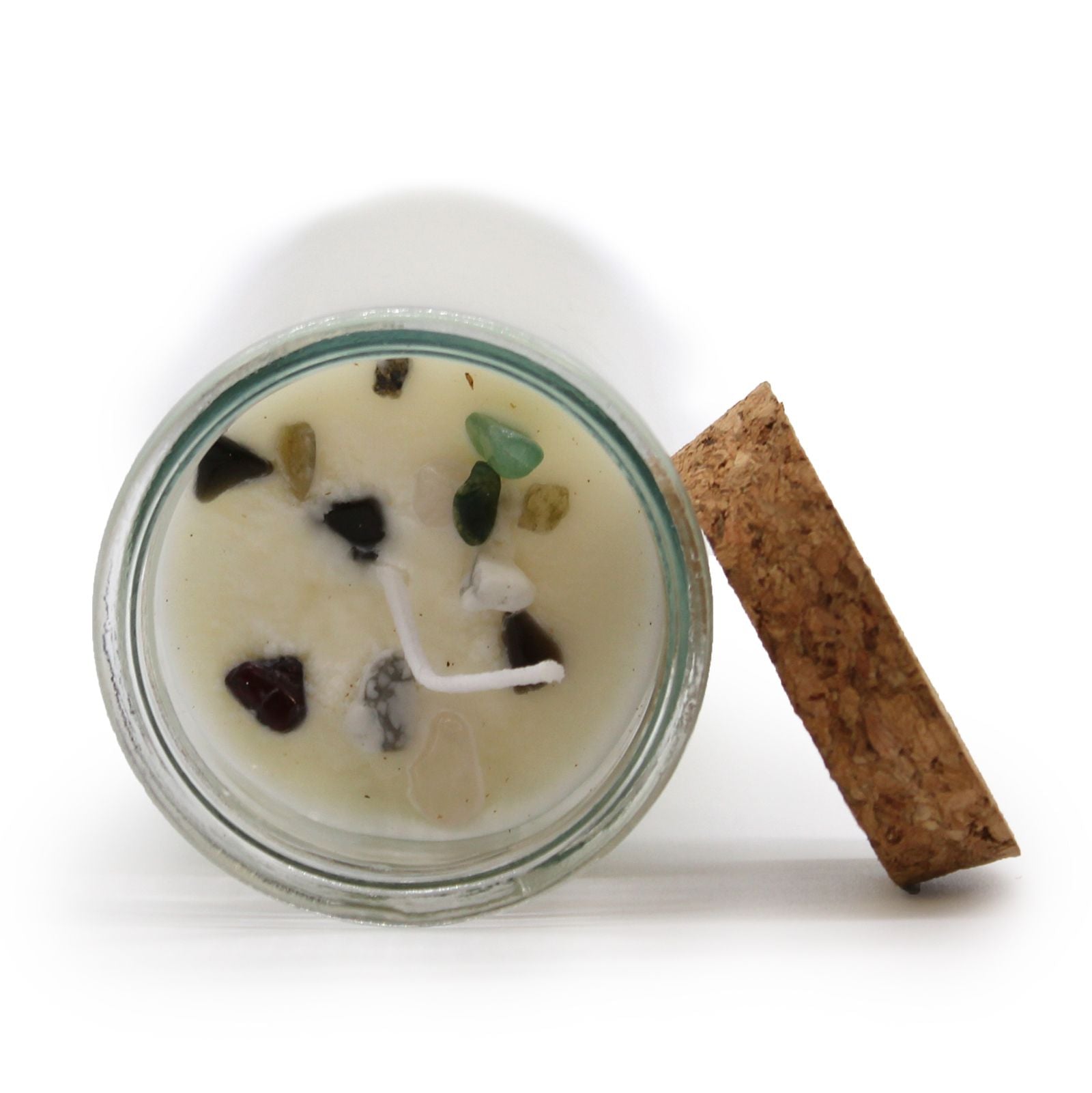 Ritualkerze mit Edelsteinen in einem Glasgefäß mit Korkdeckel.