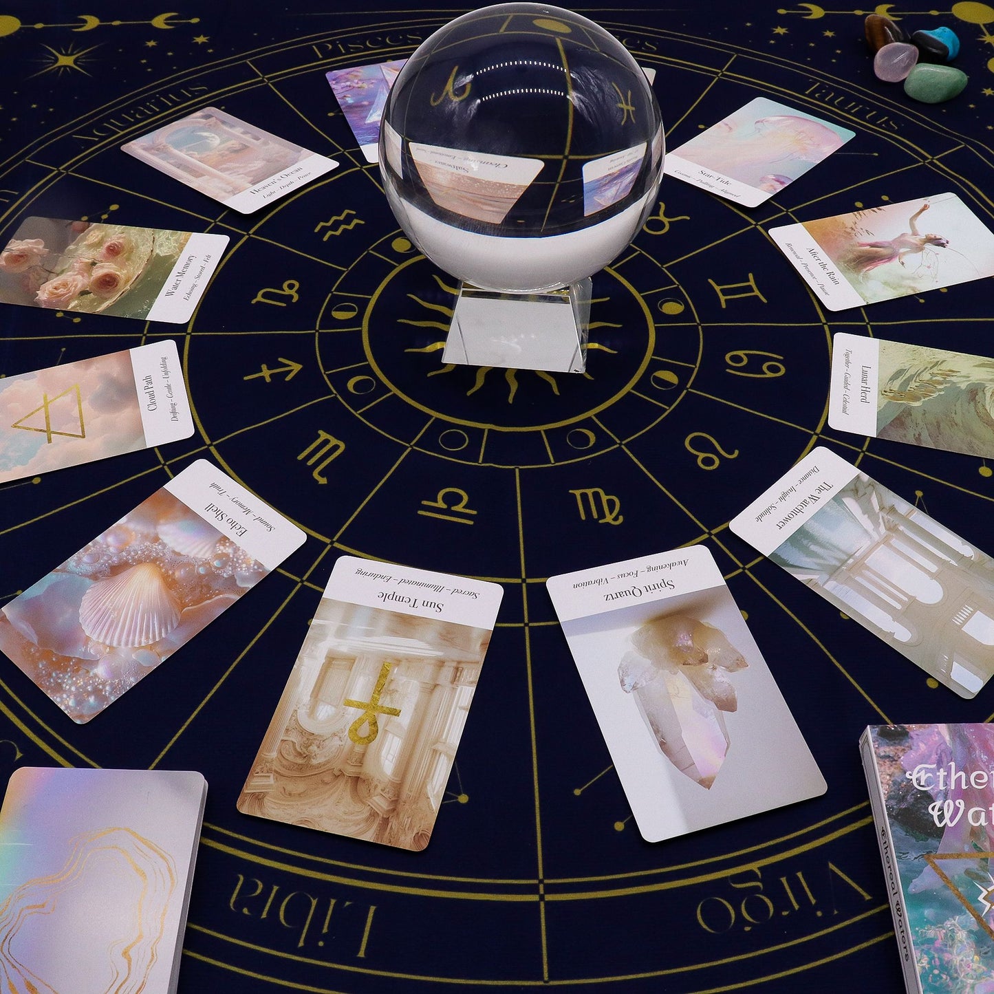 Tarot reading cloth with zodiac symbols and scattered oracle cards.