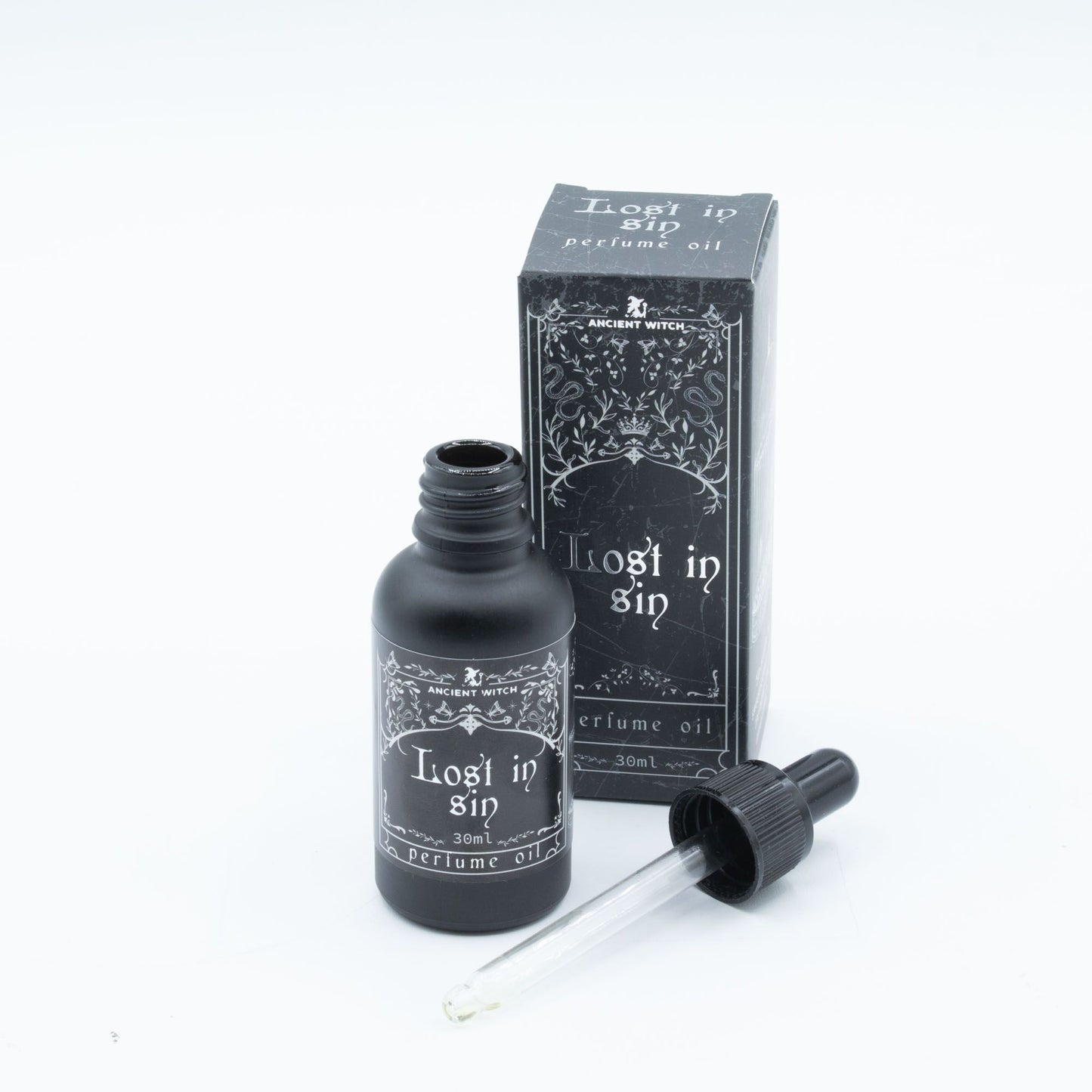 Black bottle of "Lost in Sin" perfume oil with dropper and box.