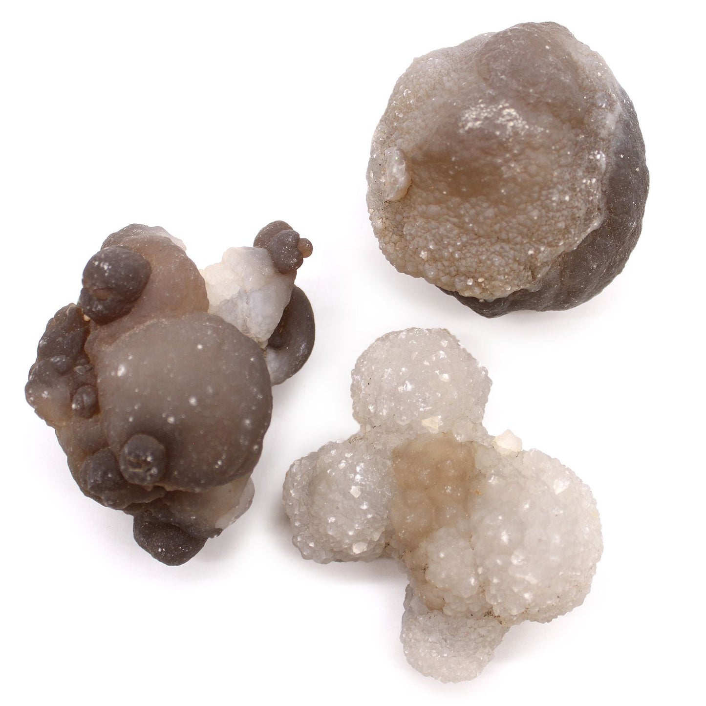 Drei rohe Chalcedon-Kristalle in verschiedenen Grautönen und Formen.