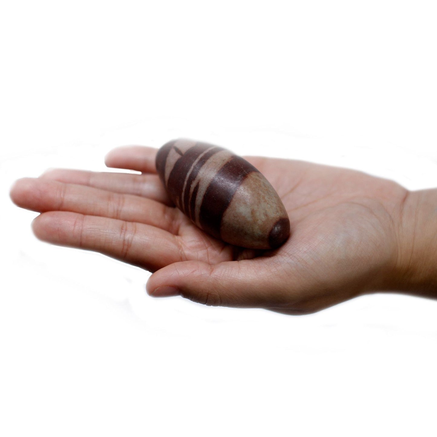 Ein Shiva Lingam Stein mit braunen Streifen liegt in einer Hand.