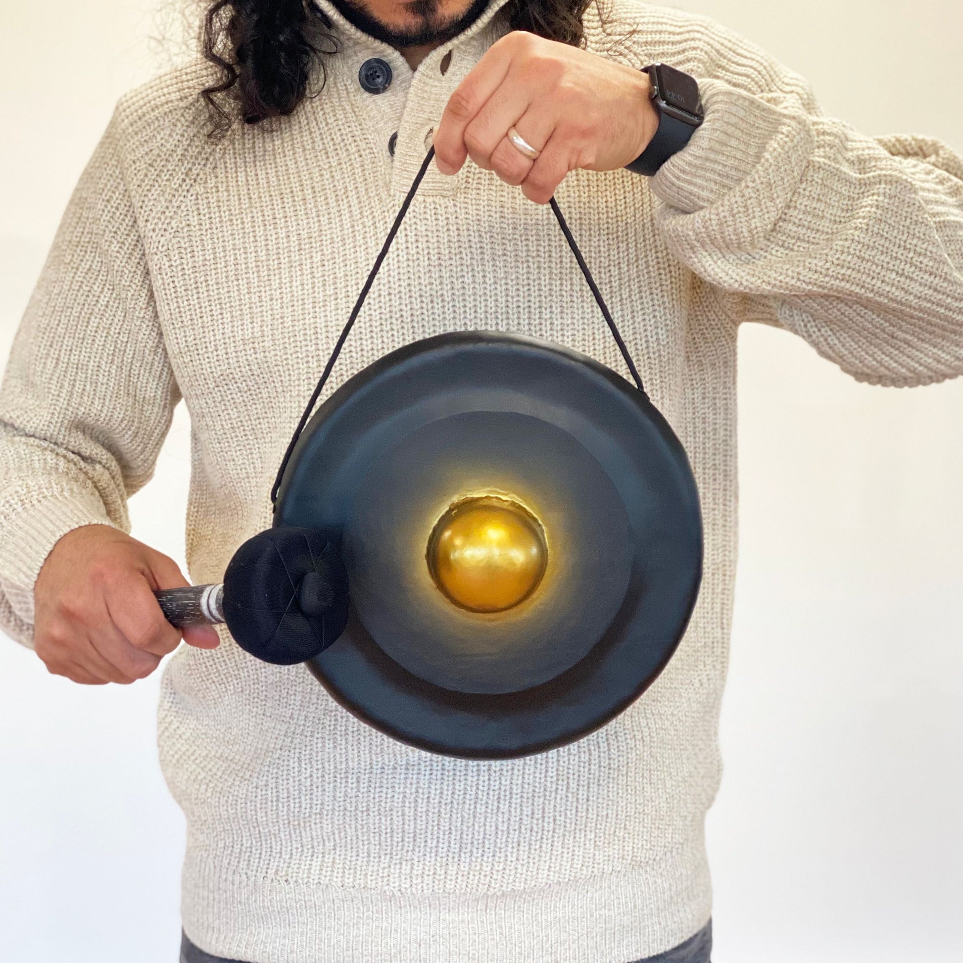 Handgefertigter schwarzer Heil-Gong mit goldenem Zentrum und Holzständer.