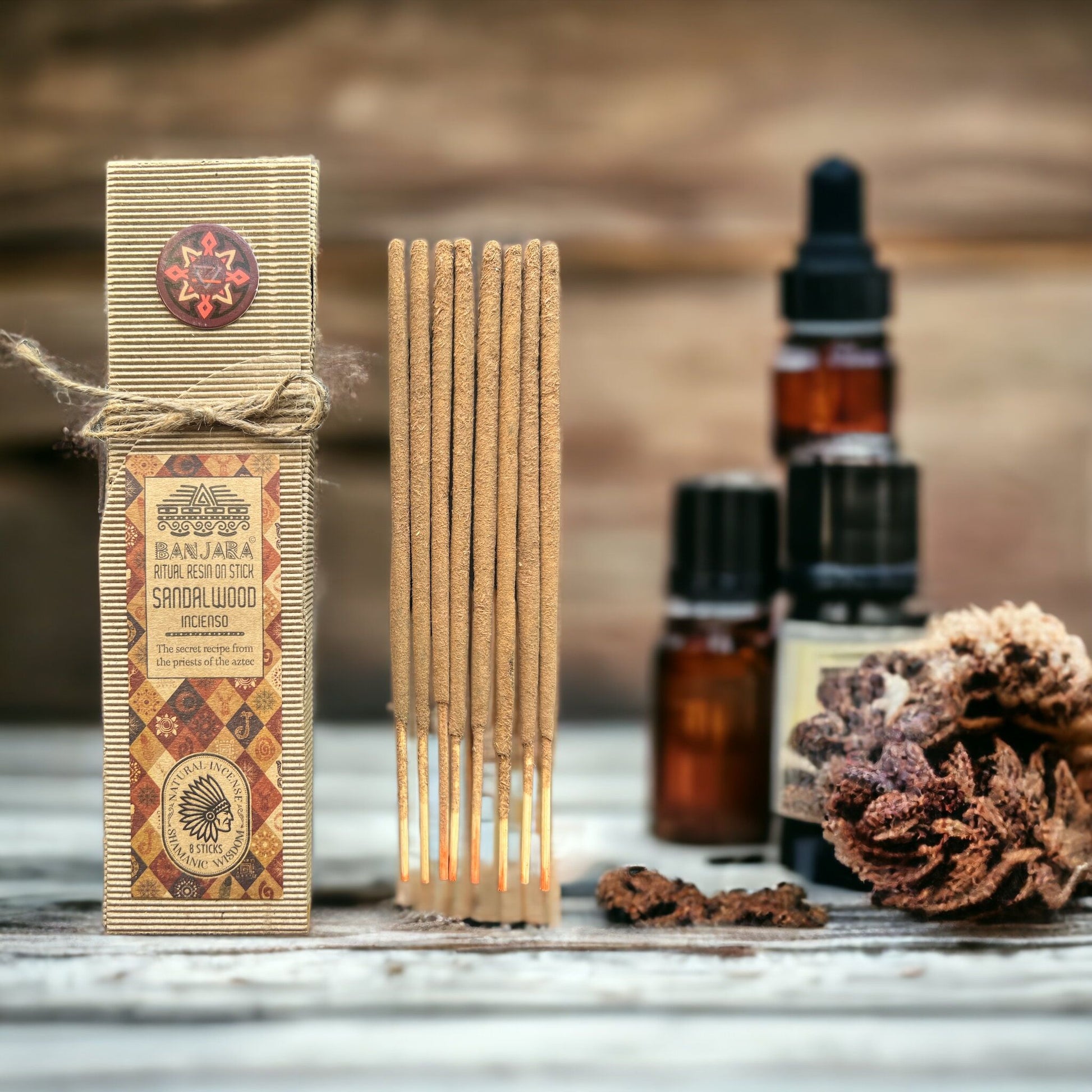 Ritual incense sticks in a box with essential oil bottles and dried plants.
