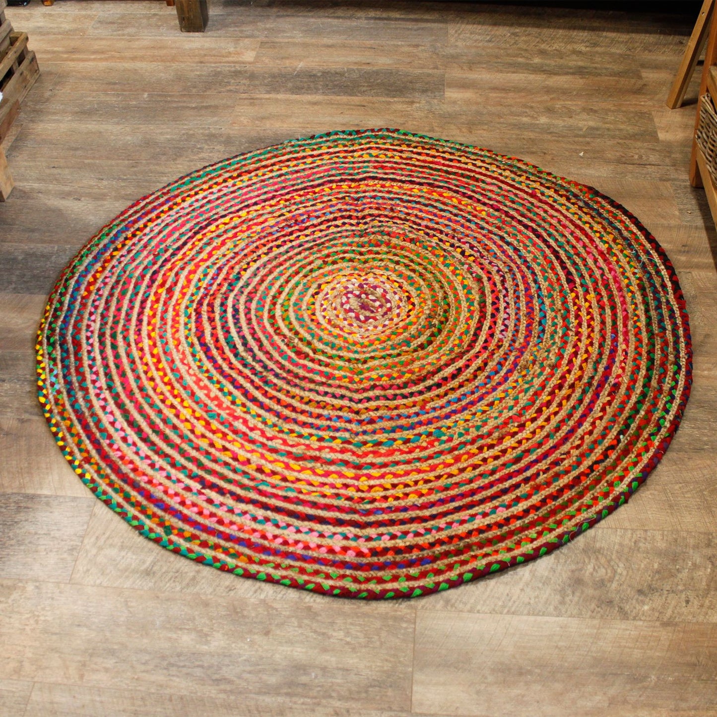 Runder Juteteppich mit recycelter Baumwolle in bunten Spiralen.