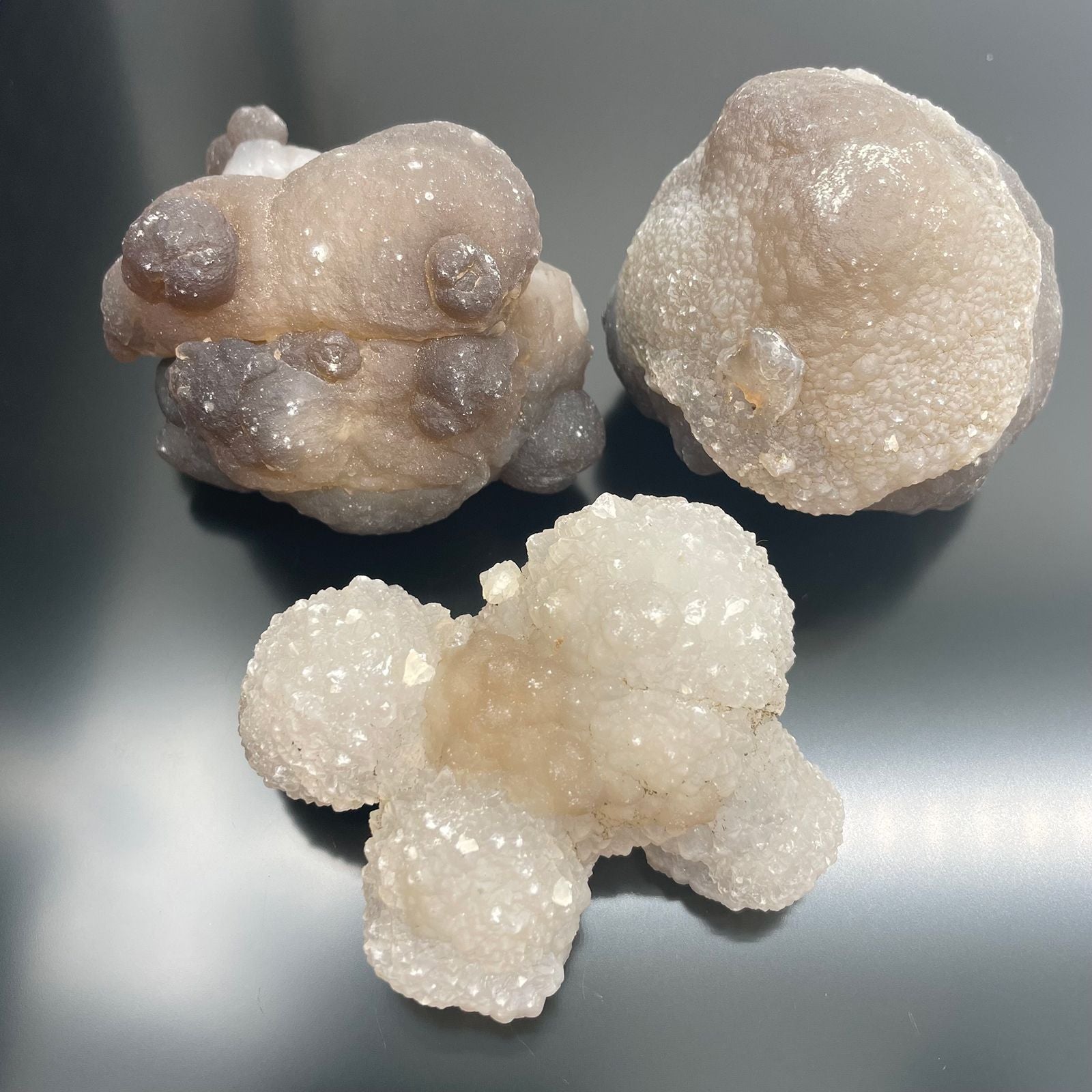 Drei rohe Chalcedon-Kristalle in verschiedenen Größen und Farben.