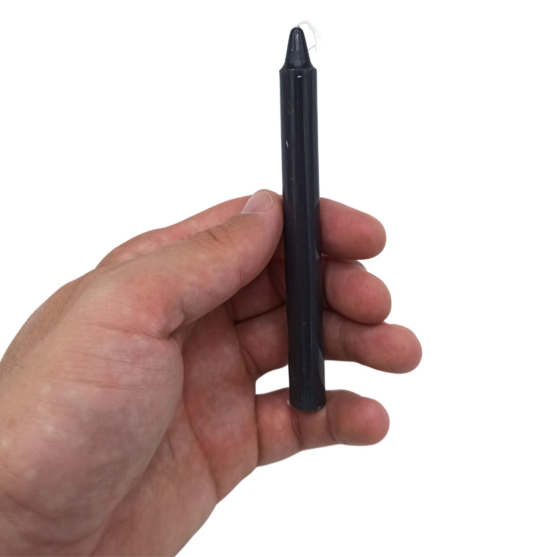 Schwarze Ritualkerze mit weißem Docht, gehalten in einer Hand.