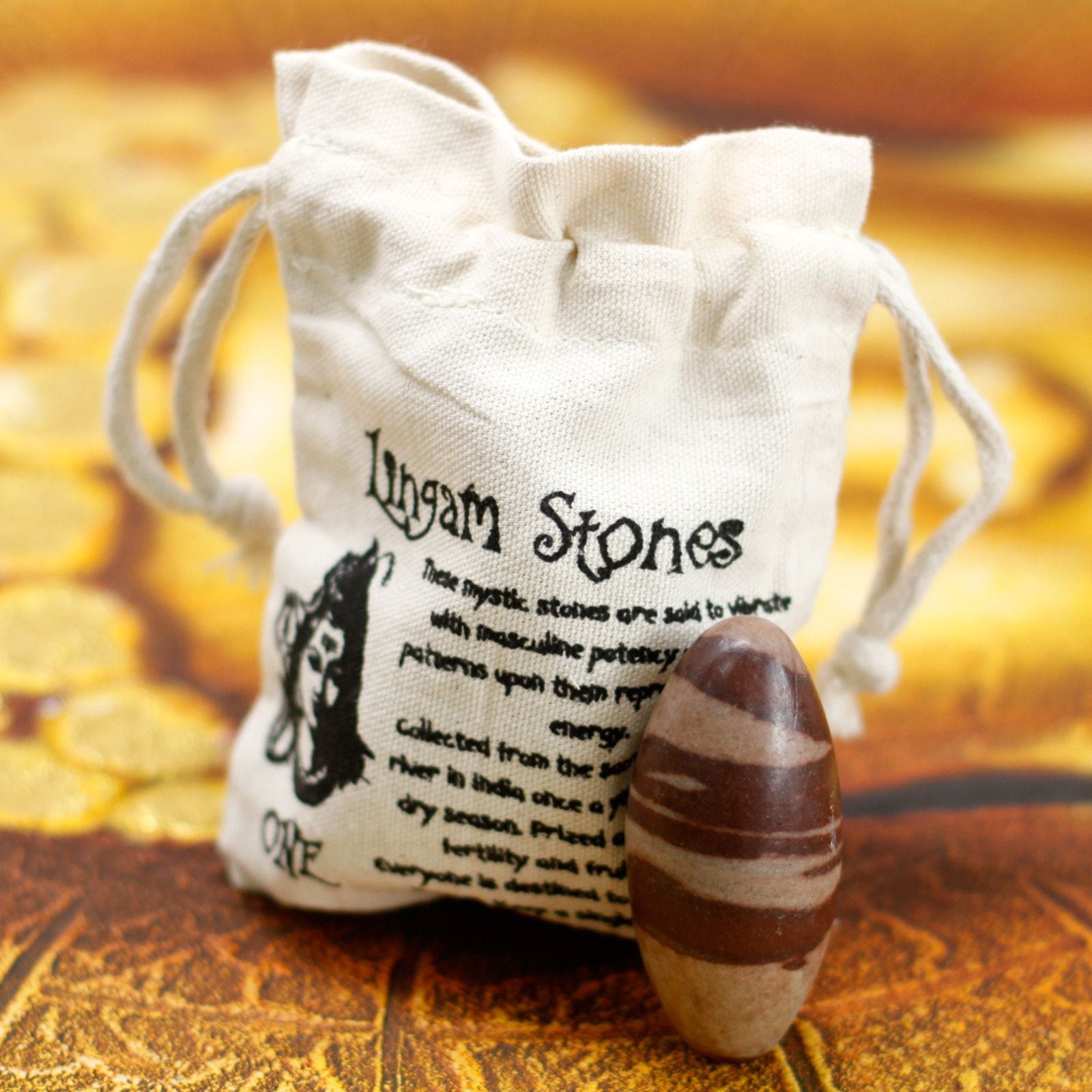 Ein Shiva Lingam Stein liegt neben einem Baumwollbeutel mit Aufdruck.