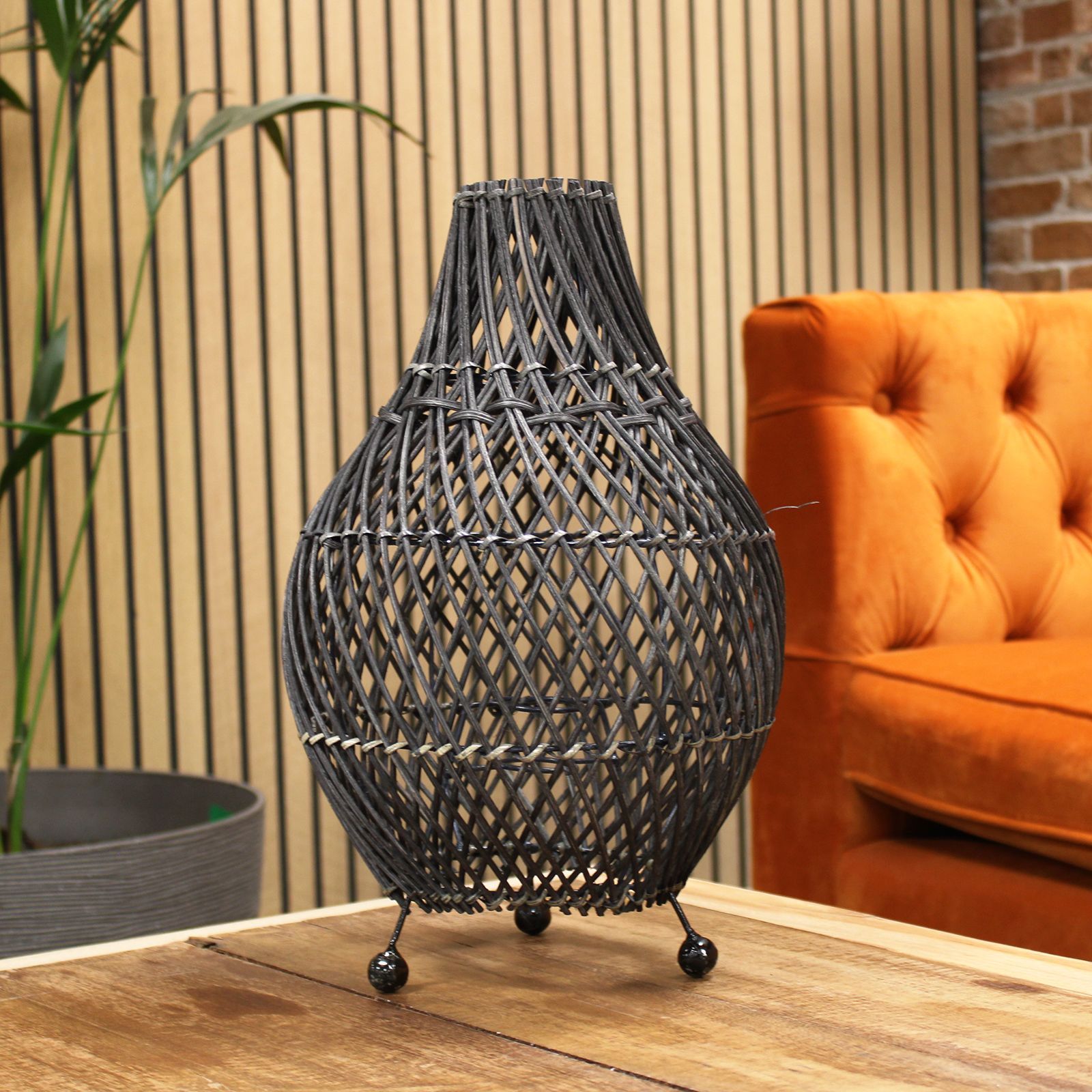 Handgefertigte Rattan Tischlampe in dunklem Geflecht mit drei Kugelfüßen.