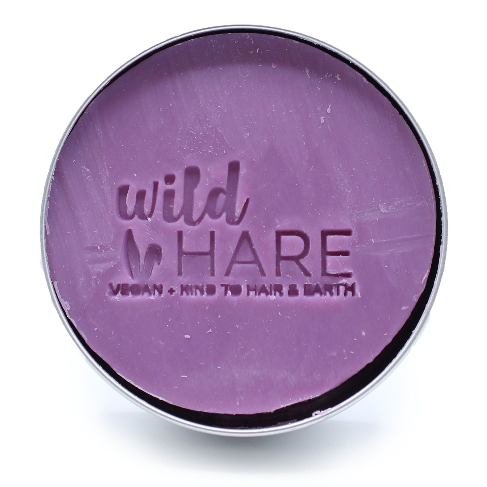 A round, purple solid shampoo bar with "wild HARE" and "VEGAN KIND TO HAIR & EARTH" embossed on it.